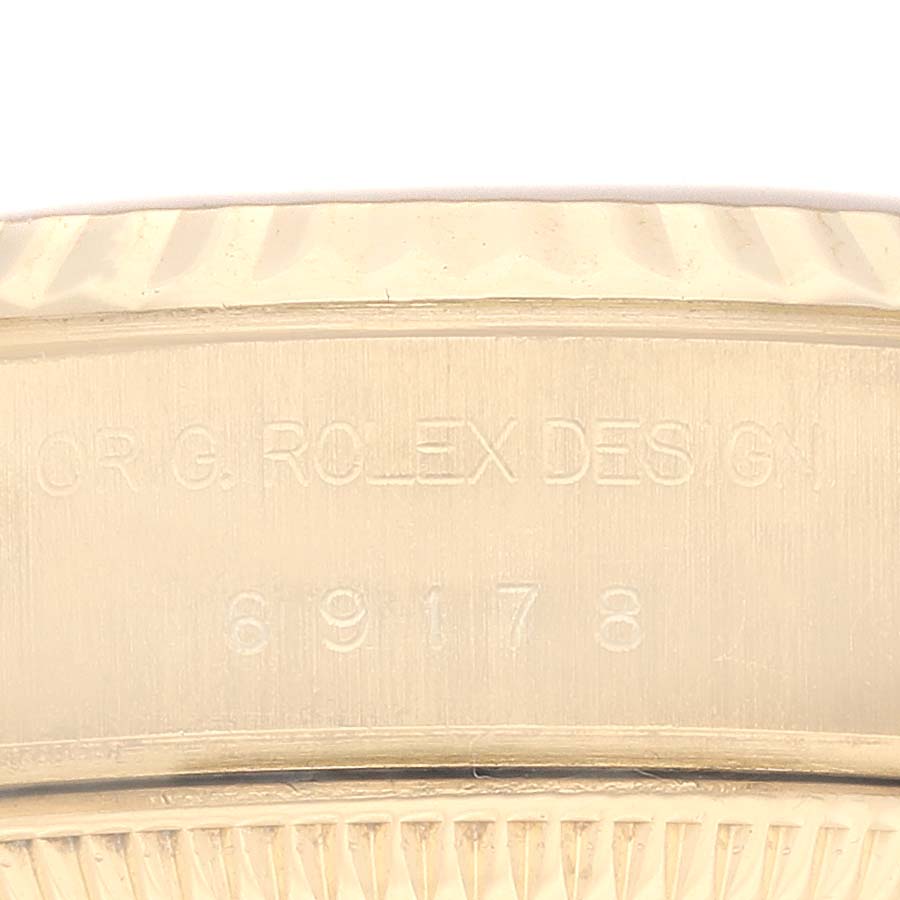 The image shows a close-up view of the engraved serial number and text on the side of a Rolex President 69178G Women
s Yellow Gold Champagne Dial 69178G Women
s Yellow Gold Champagne Dial watch bezel.
