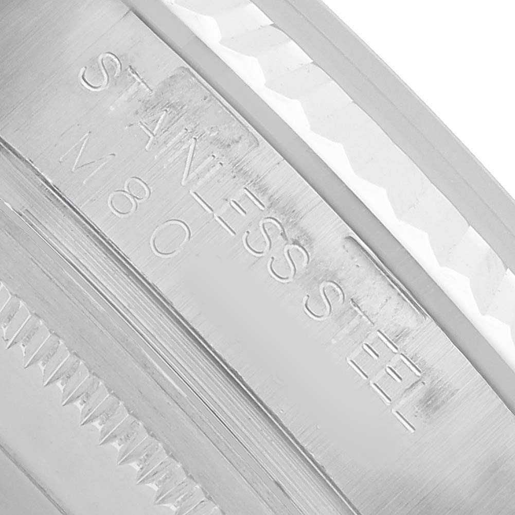 The image shows a close-up of the side of a Rolex Datejust 116234 Men's Stainless Steel Silver Dial watch, highlighting engraved text on the metal.