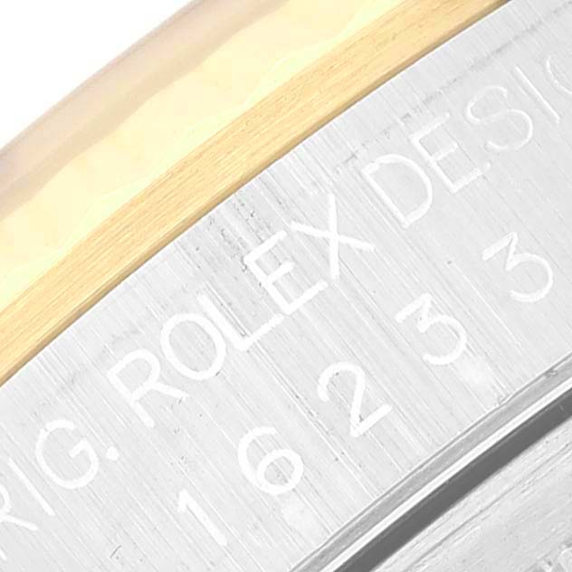 This close-up image shows the engraved bezel and part of the case of a Rolex Datejust 16233 Men's Steel and Gold (two tone) White Dial 16233 Men's Steel and Gold (two tone) White Dial watch.