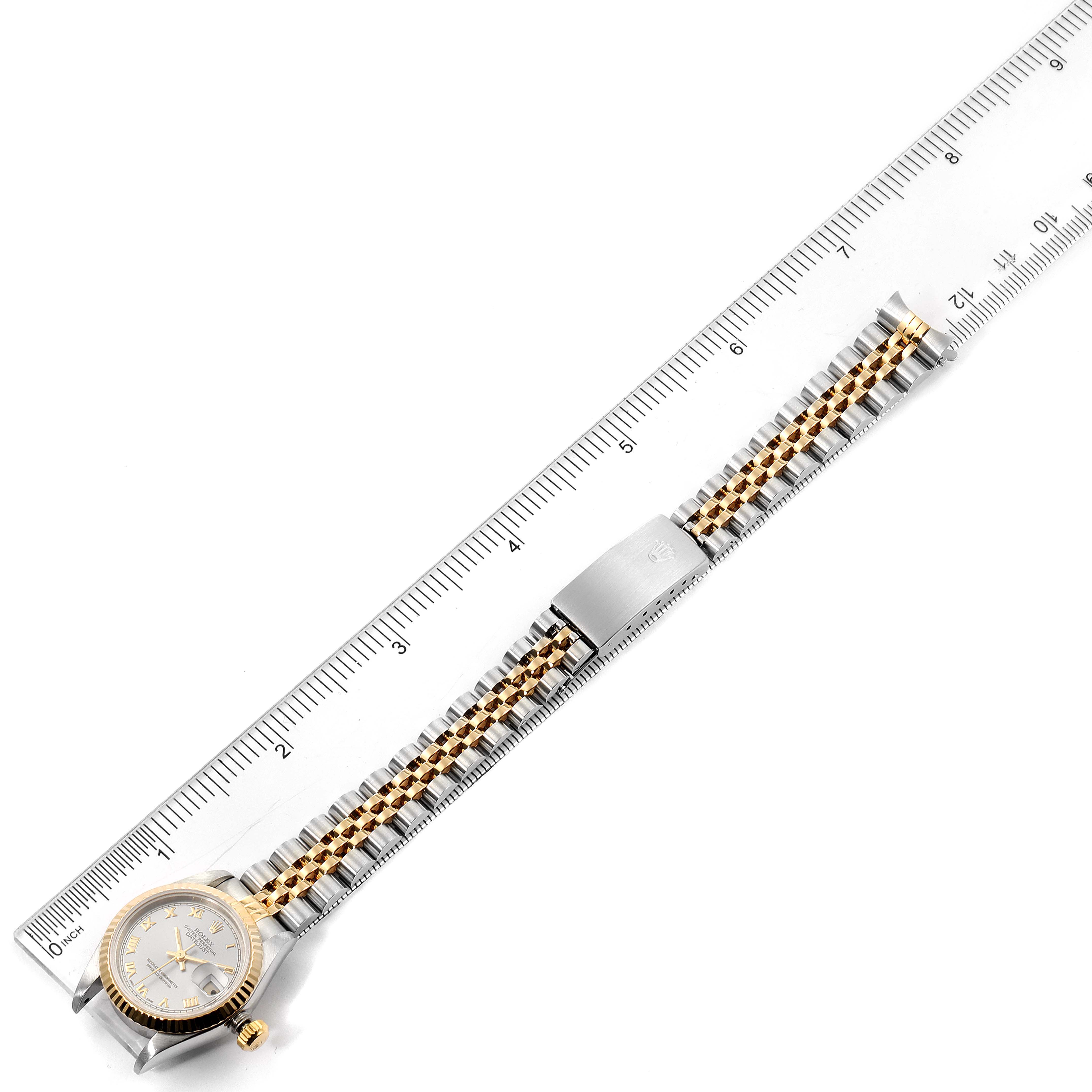 This image shows a Rolex Datejust 69173 Women
s Steel and Gold (two tone) Silver Dial 69173 Women
s Steel and Gold (two tone) Silver Dial watch laid flat next to a ruler, displaying the dial, case, and bracelet.