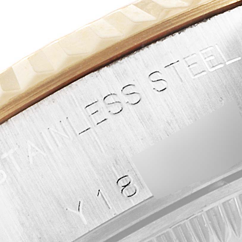The image shows a close-up of the engraved beveled edge and part of the bezel of a Rolex Datejust 79173 Women
s Steel and Gold (two tone) Silver Dial 79173 Women
s Steel and Gold (two tone) Silver Dial watch.