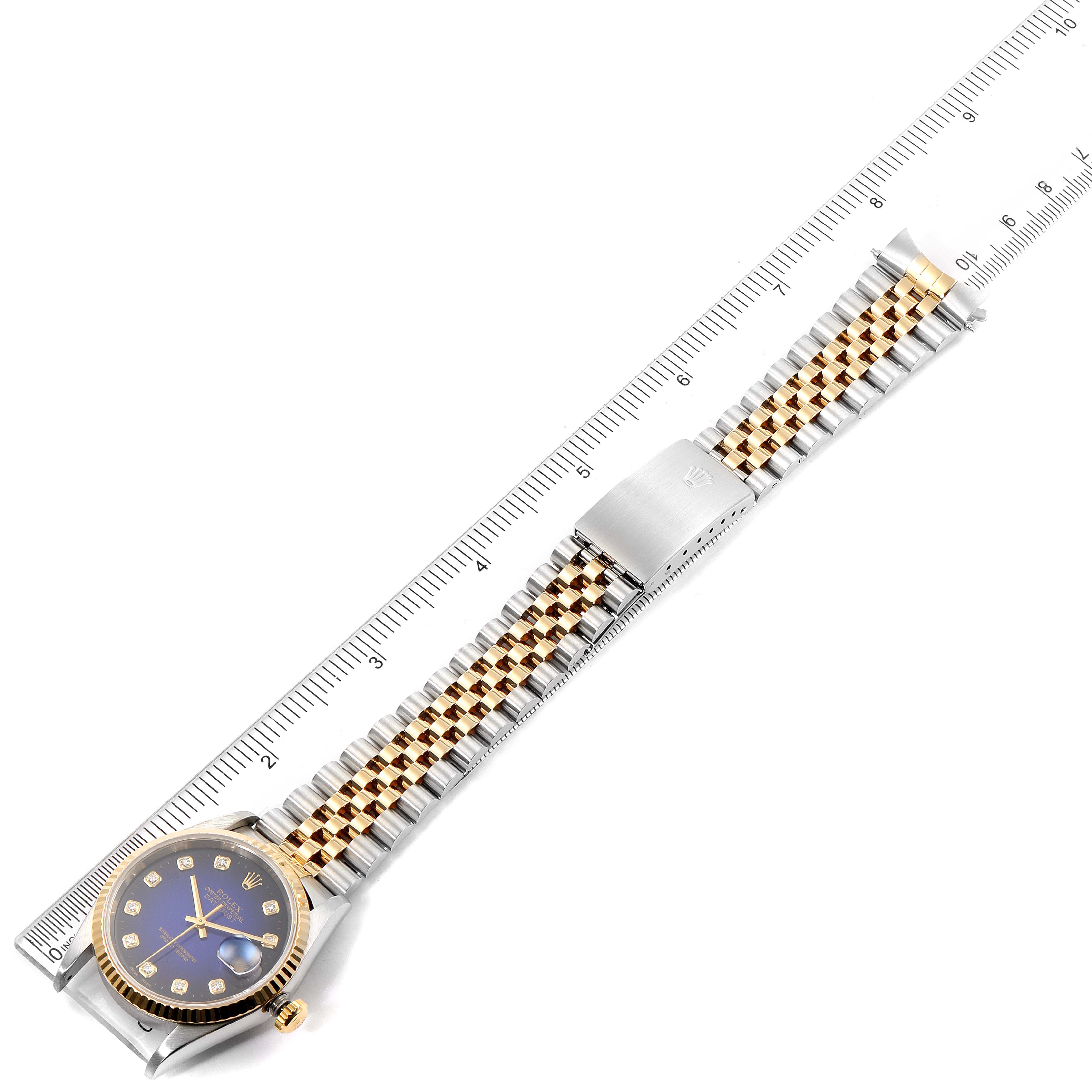 The Rolex Datejust 16233 Men's Steel and Gold (two tone) Blue Dial 16233 Men's Steel and Gold (two tone) Blue Dial watch is shown from the top, displaying the dial, bezel, and full bracelet against a ruler for scale.