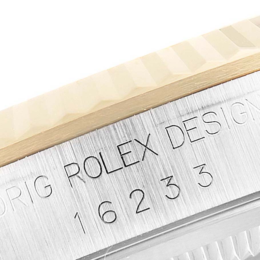 This image shows a close-up of the engraving and fluted bezel of a Rolex Datejust 16233 Men's Steel and Gold (two tone) Blue Dial 16233 Men's Steel and Gold (two tone) Blue Dial watch.