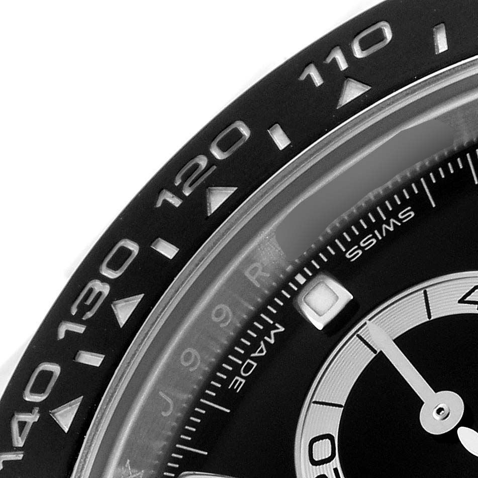 The image shows a close-up of the bezel and part of the dial of a Rolex Daytona 116500 Men's Stainless Steel Black Dial watch, highlighting its tachymetric scale.