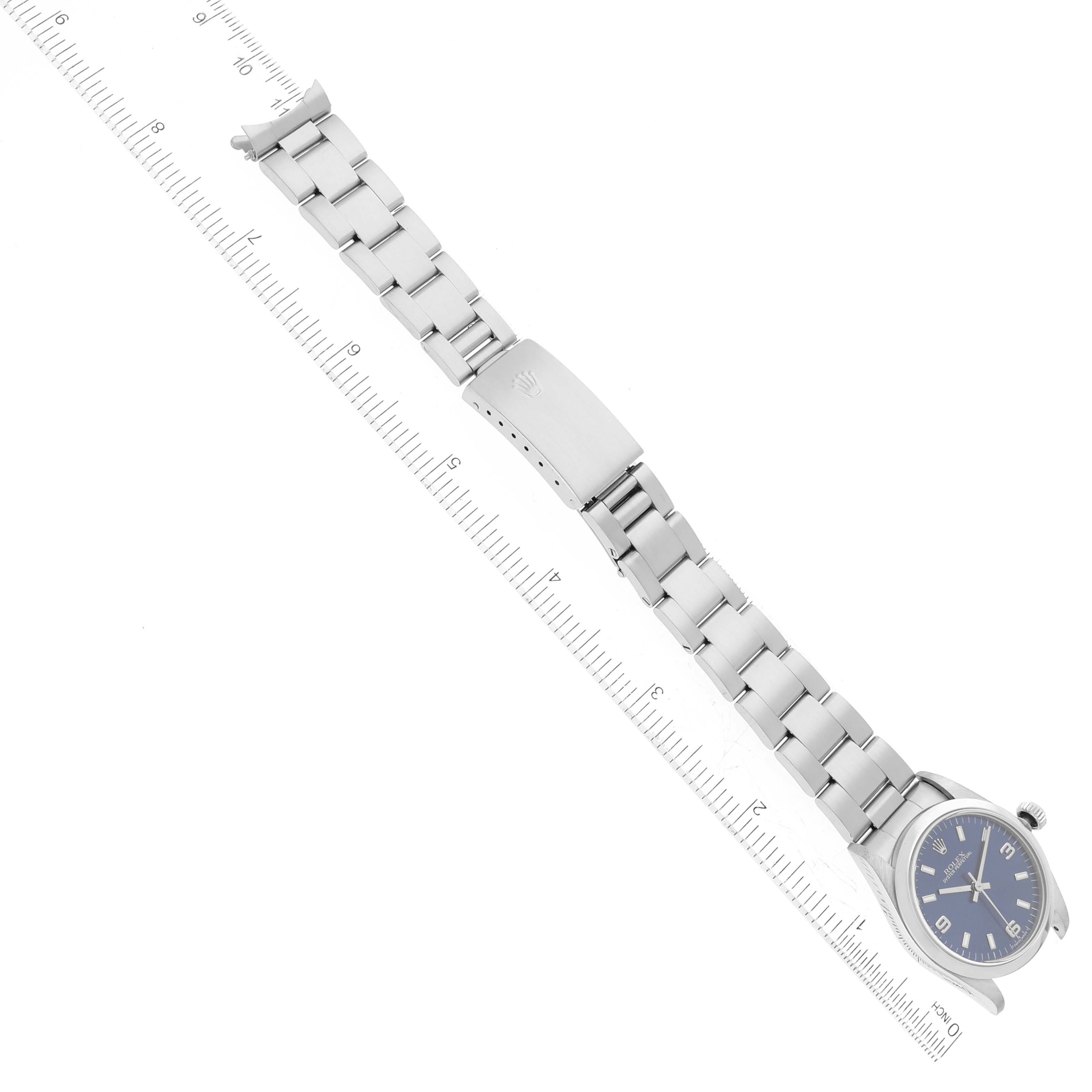This image shows a top view of a Rolex Mid-Size 67480 Women
s Stainless Steel Blue Dial 67480 Women
s Stainless Steel Blue Dial model watch with its full bracelet and a measuring scale alongside.