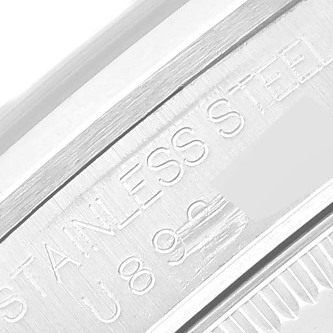 The image shows the side of a Rolex Mid-Size 67480 Women
s Stainless Steel Blue Dial 67480 Women
s Stainless Steel Blue Dial watch, focusing on the engraved stainless steel casing.