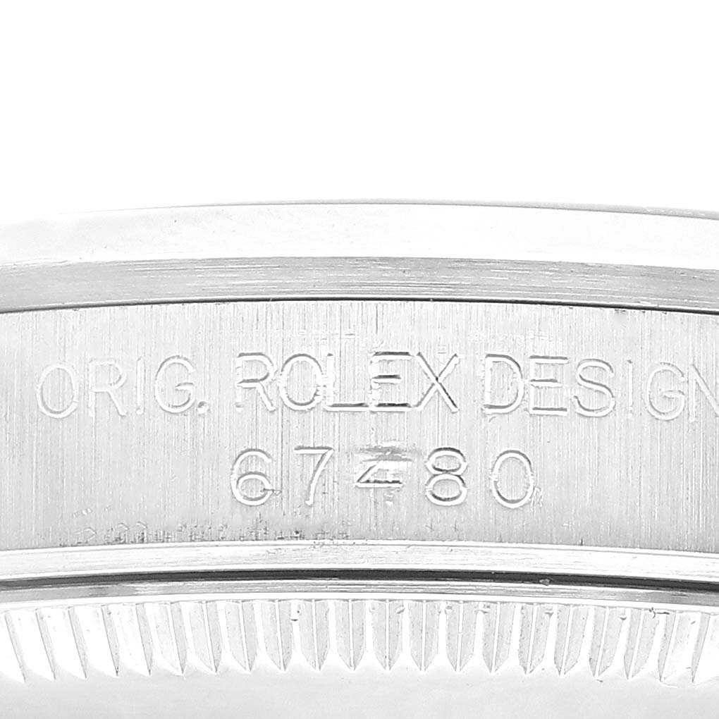 This image shows the engraved side detail of a Rolex Mid-Size 67480 Women
s Stainless Steel Blue Dial 67480 Women
s Stainless Steel Blue Dial watch bezel with its model number 67480 and brand "ORIG. ROLEX DESIGN".