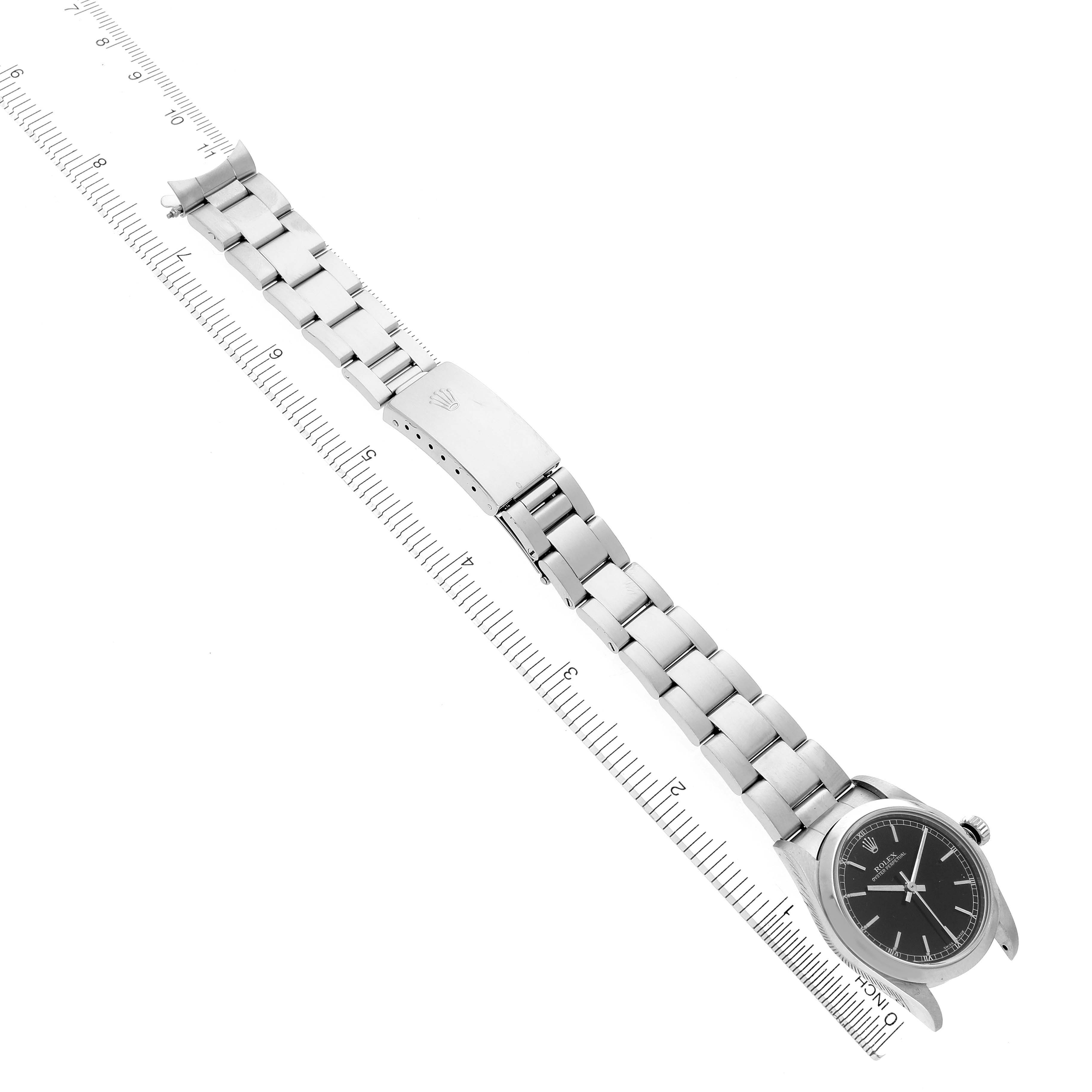 The image shows a Rolex Mid-Size 77080 Women's Stainless Steel Black Dial 77080 Women's Stainless Steel Black Dial watch laid flat, displaying the bracelet and face alongside a ruler for size reference.