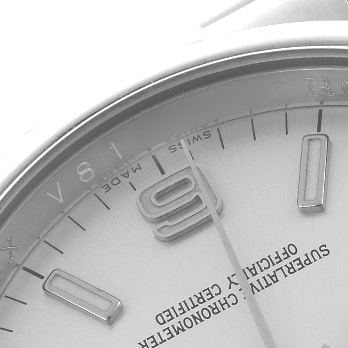 The image shows a close-up of the dial on a Rolex Oyster Perpetual 116000 Men's Stainless Steel Silver Dial 116000 Men's Stainless Steel Silver Dial, focusing on the top part with the "09" marker.