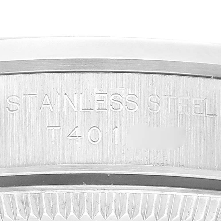 This image shows a close-up of the case side of a Rolex Oyster Perpetual 67180 Women's Stainless Steel Blue Dial 67180 Women's Stainless Steel Blue Dial watch, displaying the "STAINLESS STEEL" engraving.