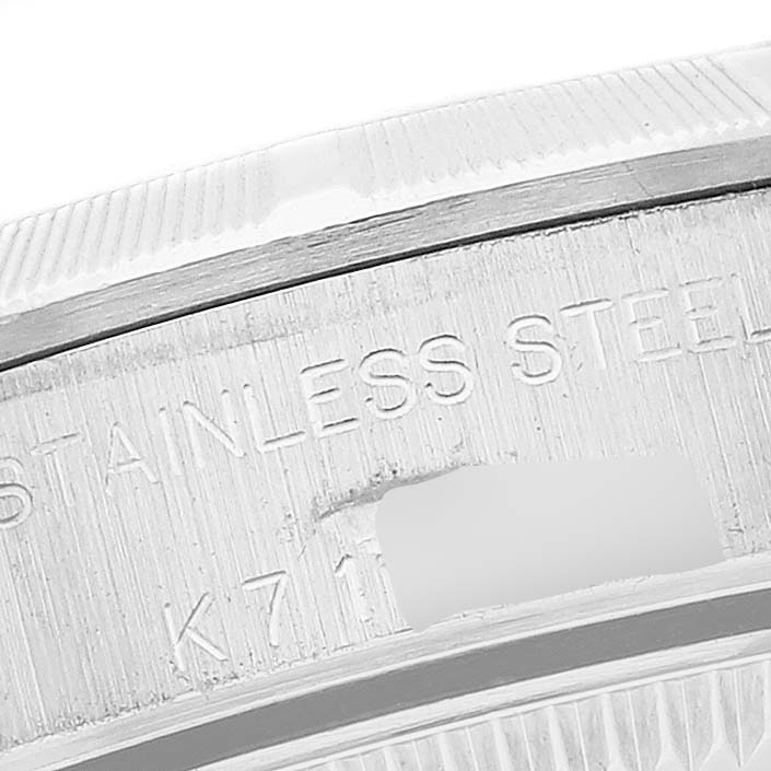 This close-up image shows the engraved stainless steel section of a Rolex Oyster Perpetual 76030 Women
s Stainless Steel Pink Dial 76030 Women
s Stainless Steel Pink Dial watch.