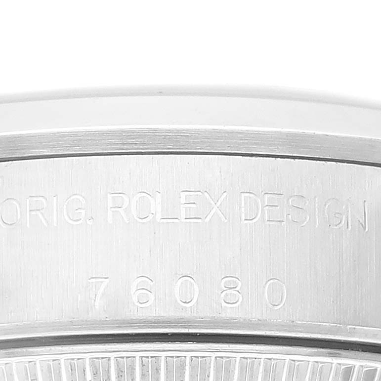This image shows a close-up of the case back edge and engraving on a Rolex Oyster Perpetual 76080 Women's Stainless Steel Orange Dial 76080 Women's Stainless Steel Orange Dial watch.