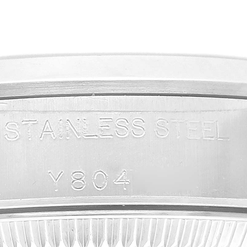 The image shows a close-up of the side of the stainless steel case of a Rolex Oyster Perpetual 76080 Women's Stainless Steel Orange Dial 76080 Women's Stainless Steel Orange Dial watch.