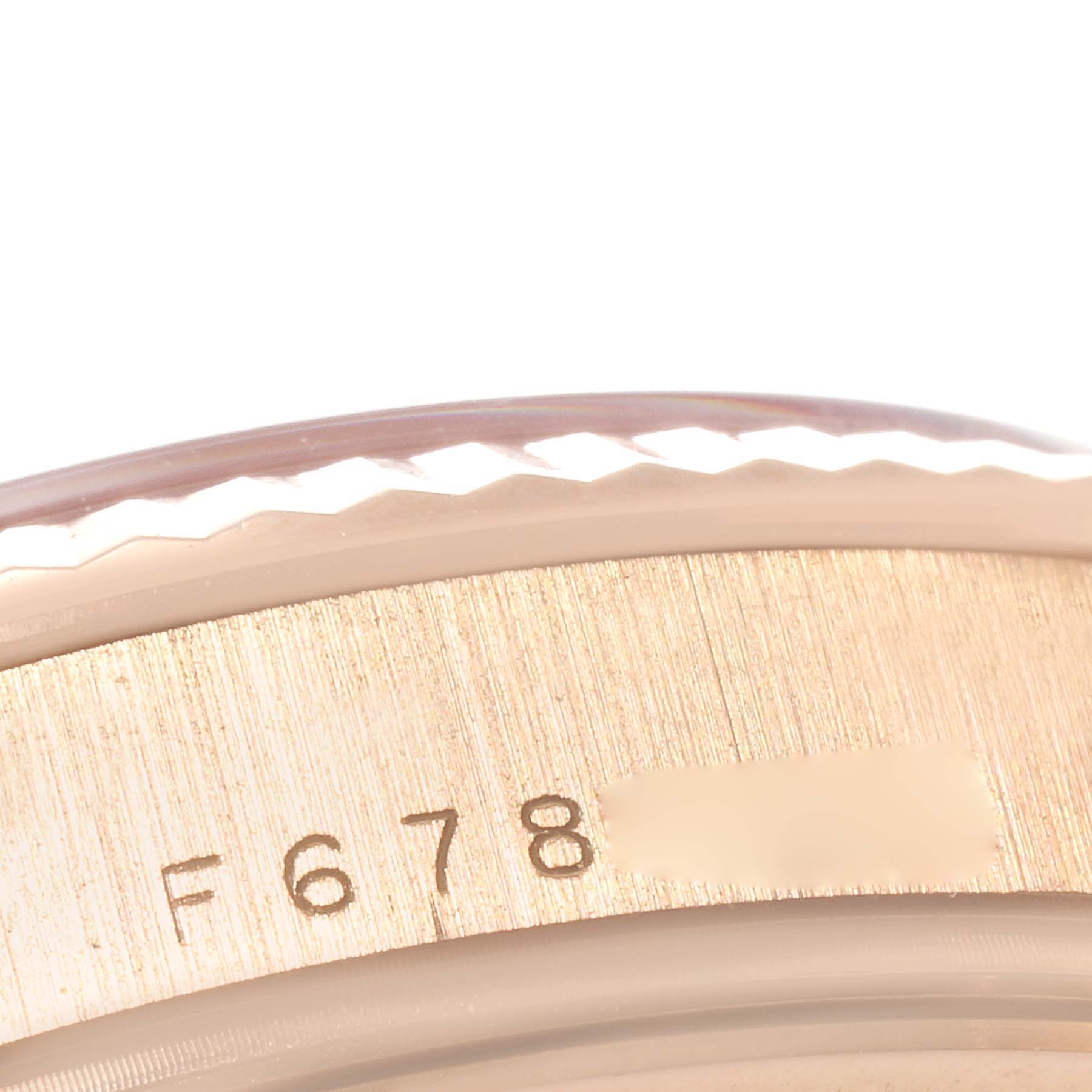 This close-up image showcases the serial number engraving on the bezel of a Rolex President 118235 Men's Rose Gold Mother of Pearl Dial 118235 Men's Rose Gold Mother of Pearl Dial model watch.