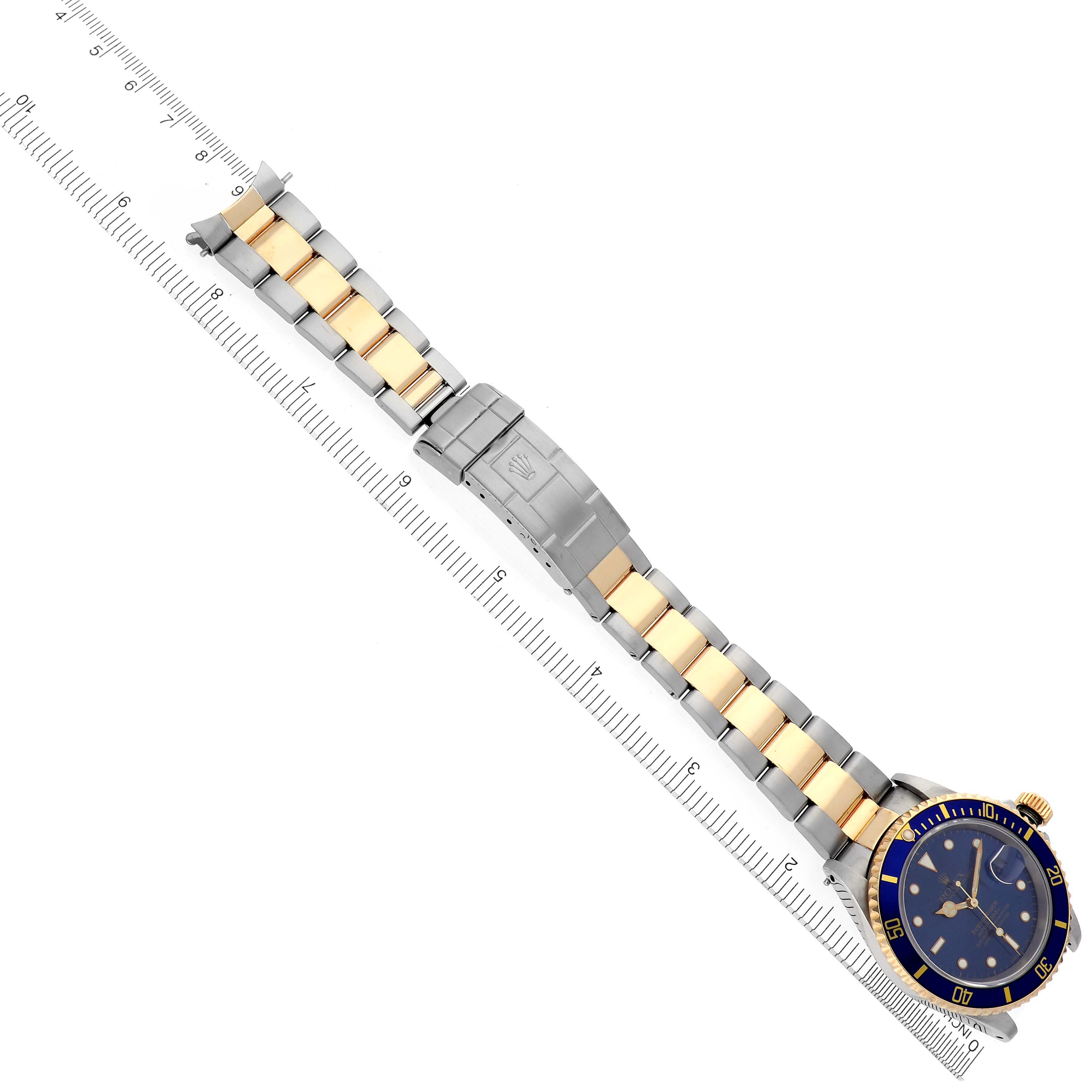 The image shows a top-down view of a Rolex Submariner 16613 Men's Steel and Gold (two tone) Blue Dial 16613 Men's Steel and Gold (two tone) Blue Dial, highlighting the blue dial, bezel, and two-tone metal bracelet.