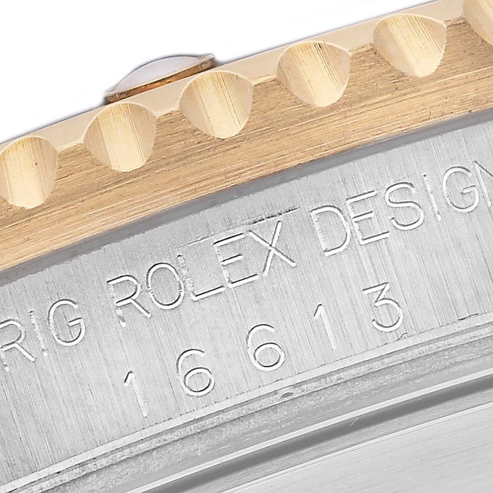 The image shows a close-up of the bezel and engraved model number on a Rolex Submariner 16613 Men's Steel and Gold (two tone) Blue Dial 16613 Men's Steel and Gold (two tone) Blue Dial watch's side.