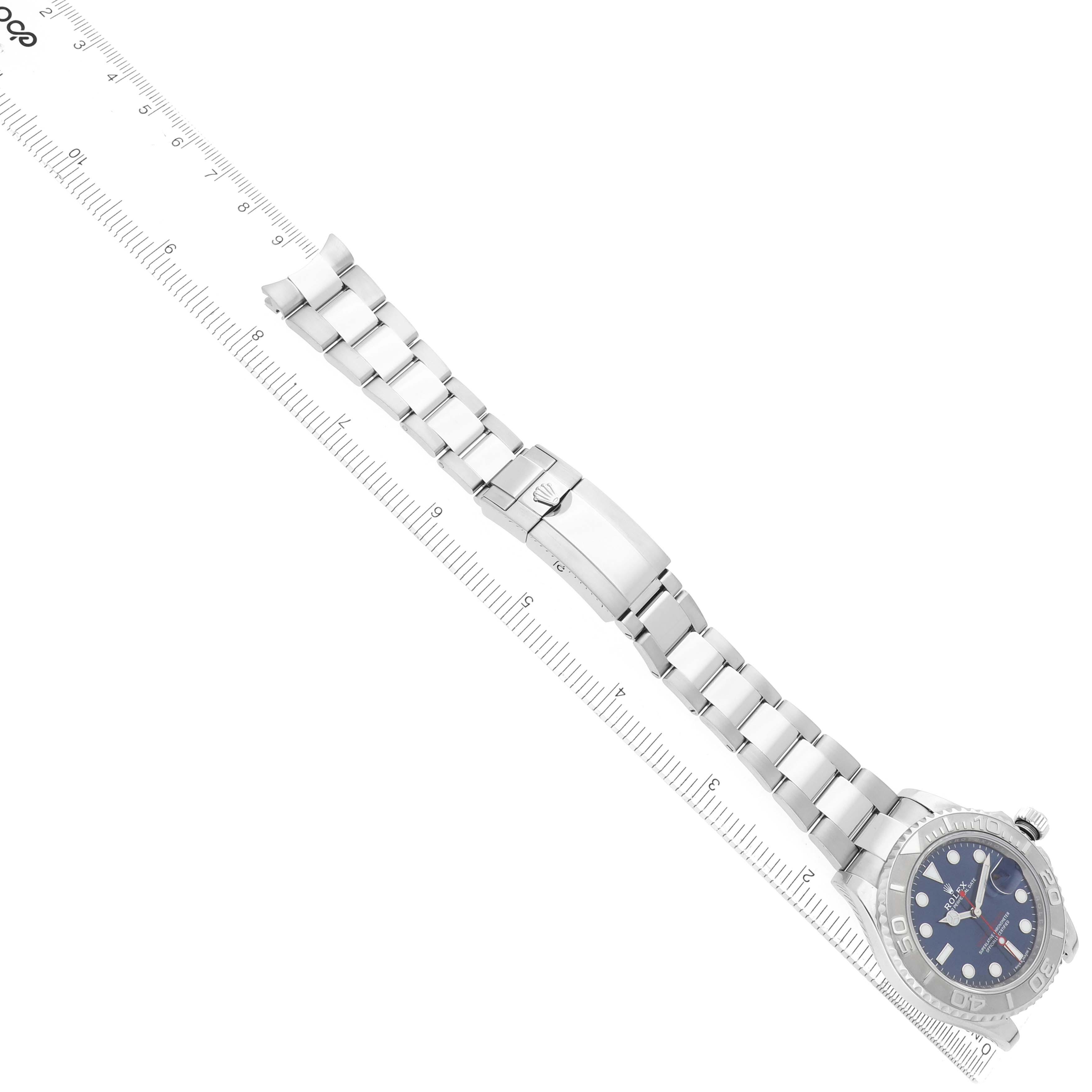 The image shows a Rolex Yacht-Master 116622 Men's Stainless Steel Blue Dial watch laid flat with its bracelet extended, next to a ruler for scale.