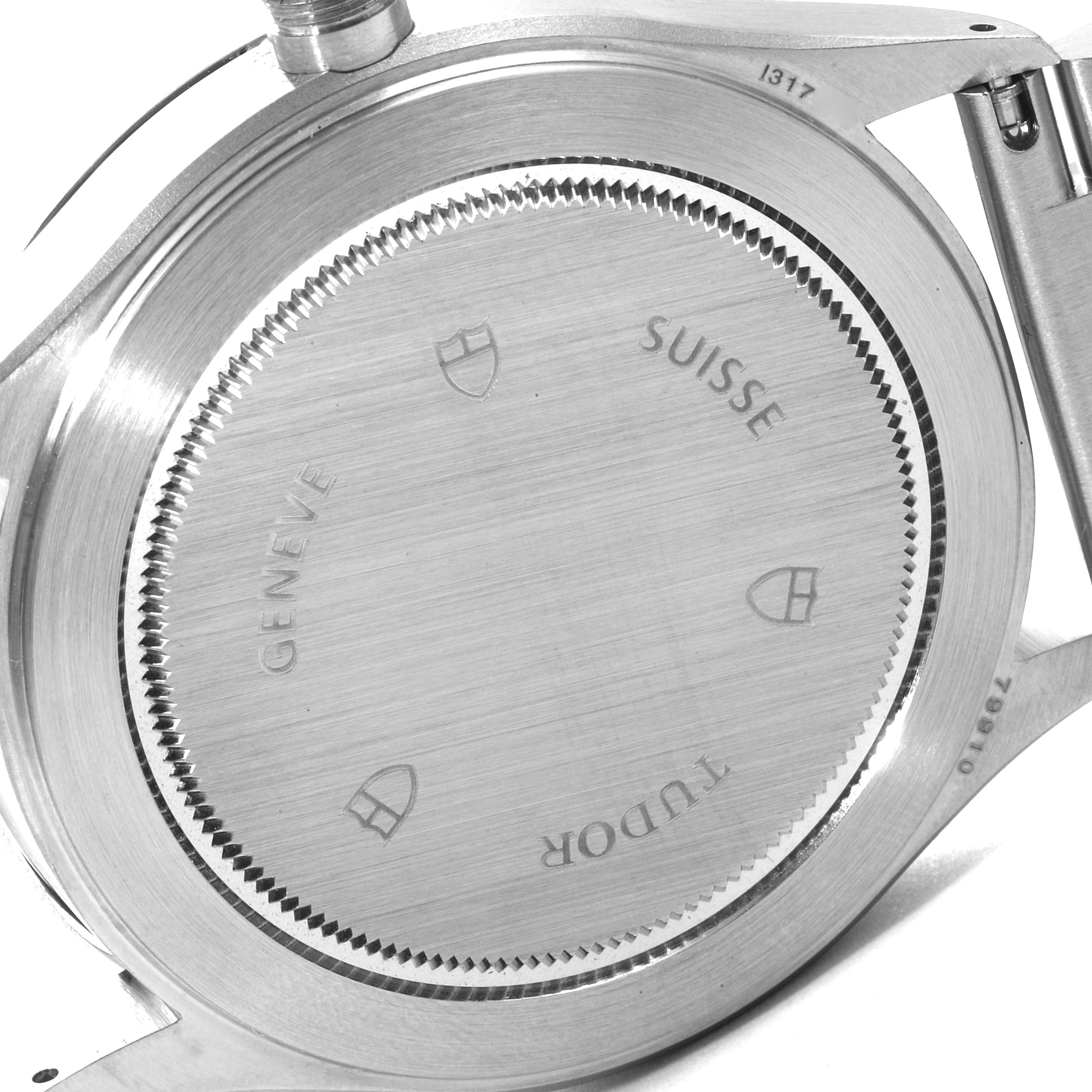 The image shows the back casing of a Tudor Heritage Ranger 79910 Men's Stainless Steel Black Dial 79910 Men's Stainless Steel Black Dial watch, highlighting the engravings and screw-down caseback.