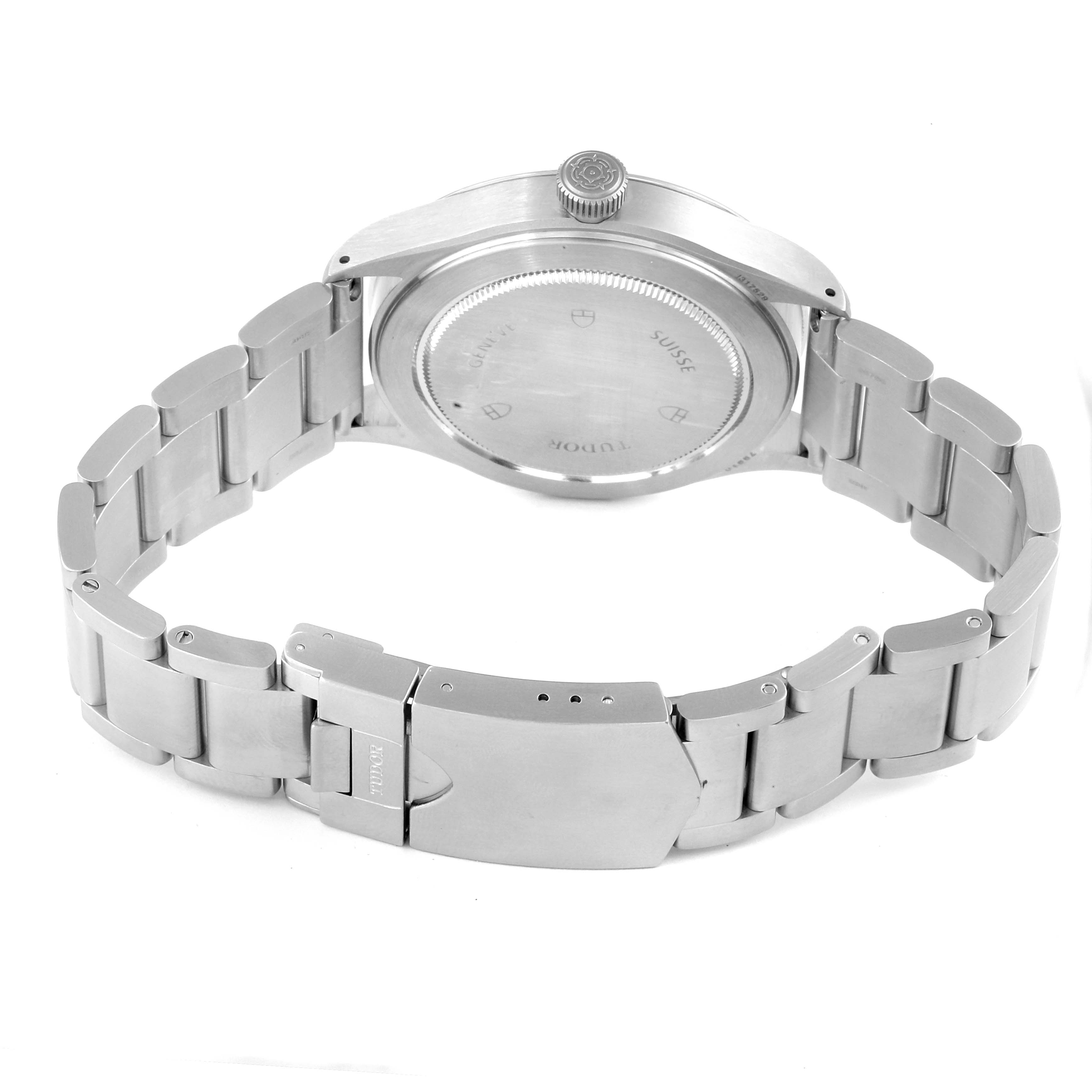 The image shows the backside of a Tudor Heritage Ranger 79910 Men's Stainless Steel Black Dial 79910 Men's Stainless Steel Black Dial watch, highlighting its caseback, crown, and metal bracelet with a clasp.