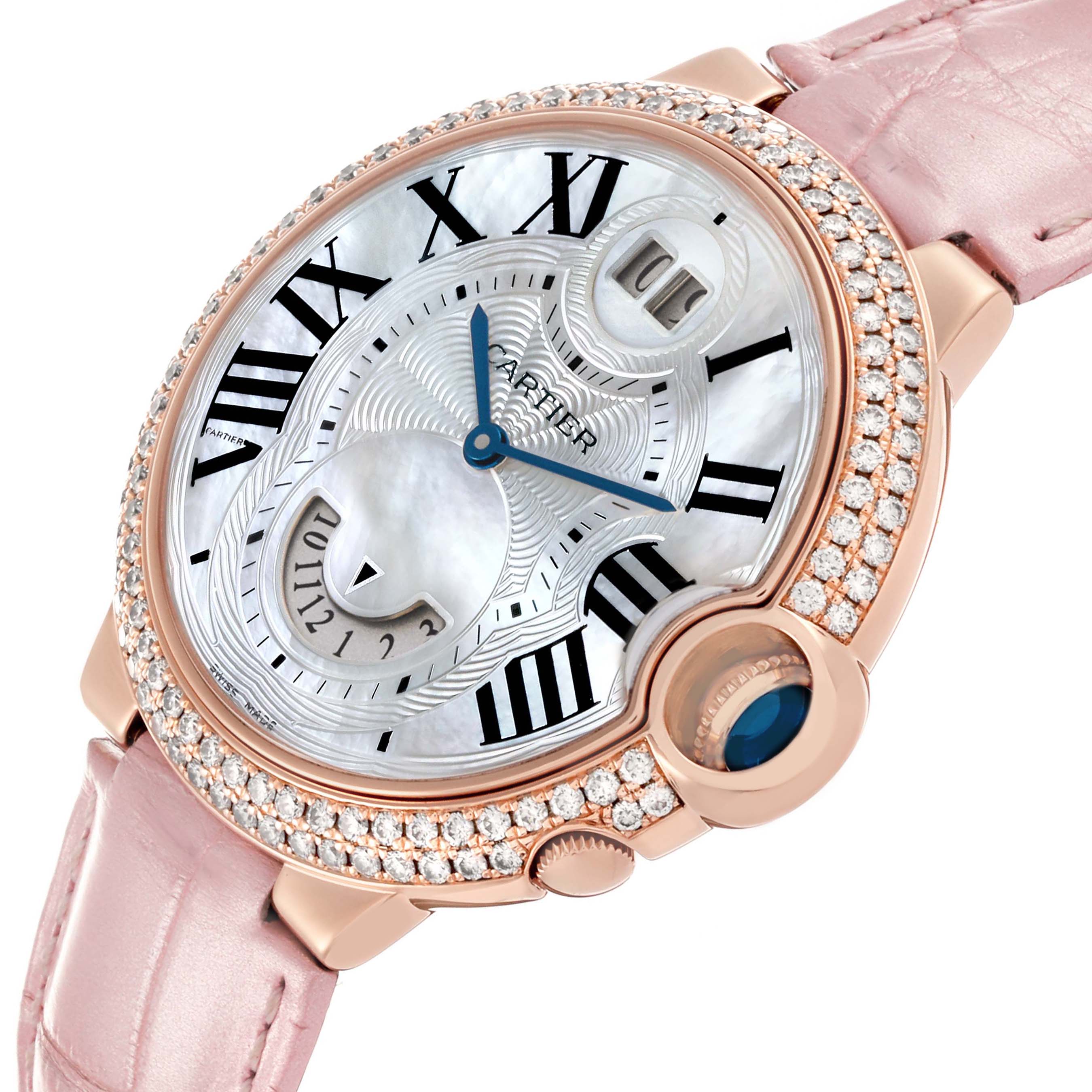 The Cartier Ballon Bleu WE902018 Women's Rose Gold Mother of Pearl Dial watch is shown at a tilted angle, highlighting its diamond bezel, dial, pink strap, and crown.