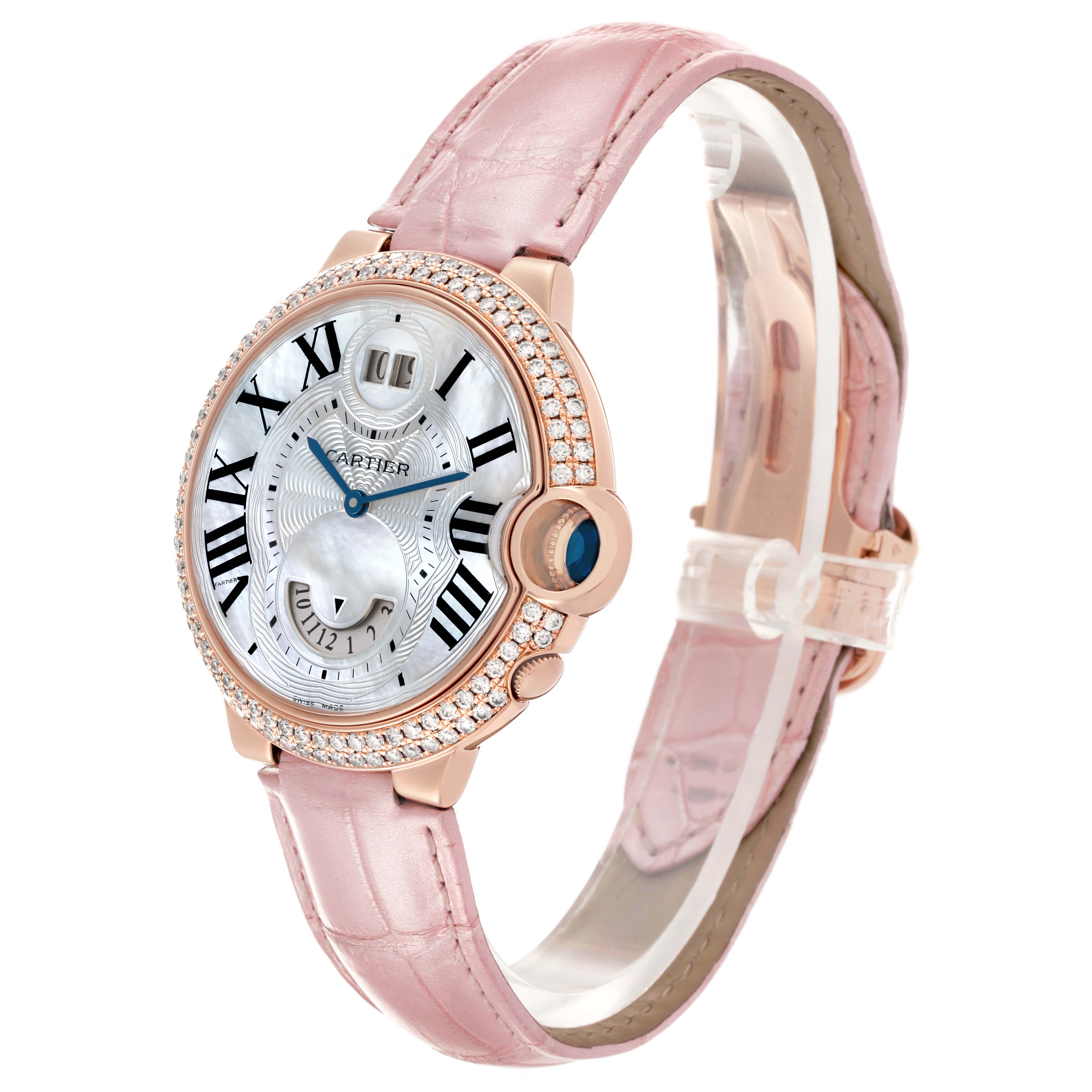 The Cartier Ballon Bleu WE902018 Women's Rose Gold Mother of Pearl Dial watch is shown in a three-quarter angle, highlighting its pink strap and diamond-encrusted bezel.