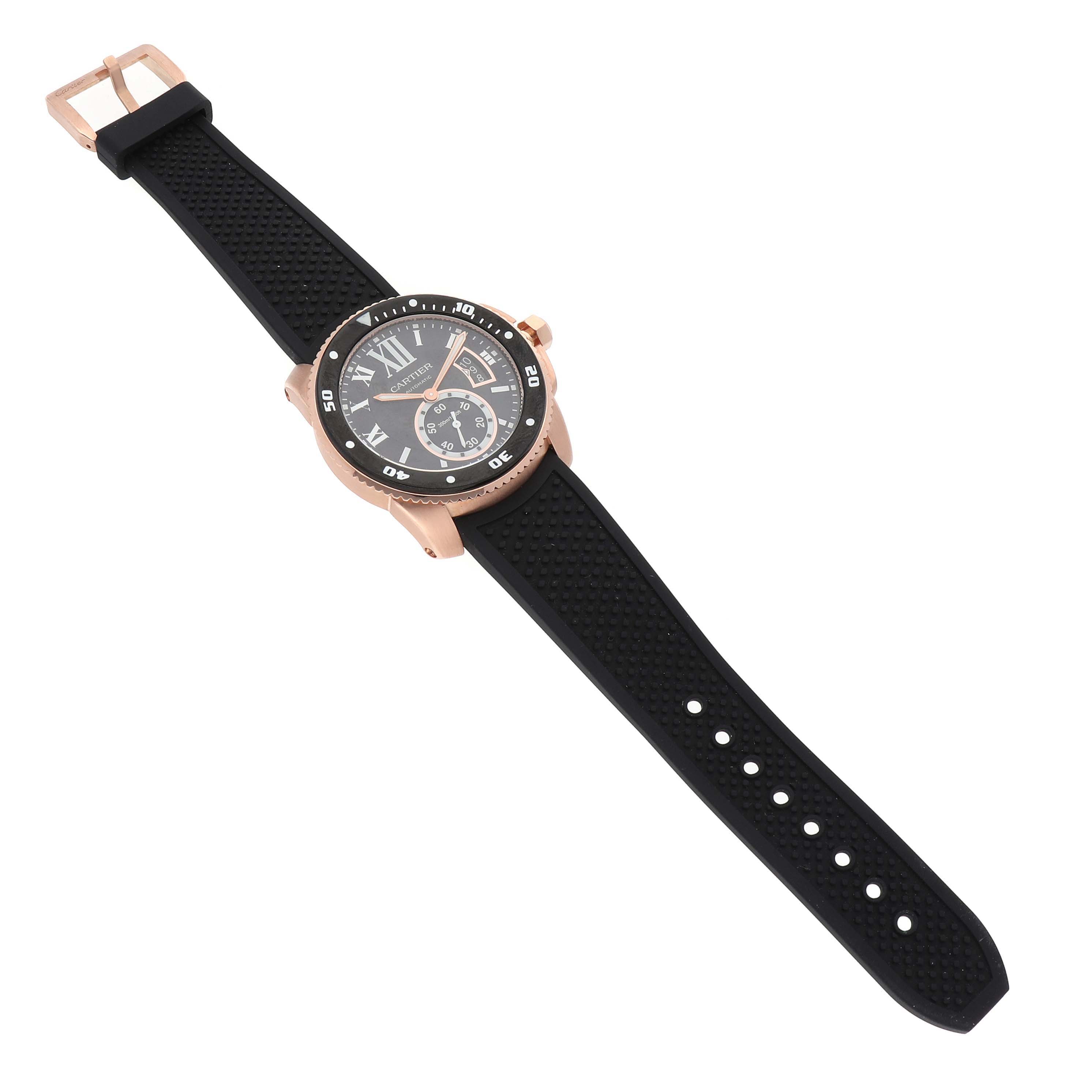 The Calibre de Cartier watch is shown at an angled top view, displaying its face, bezel, and black strap.