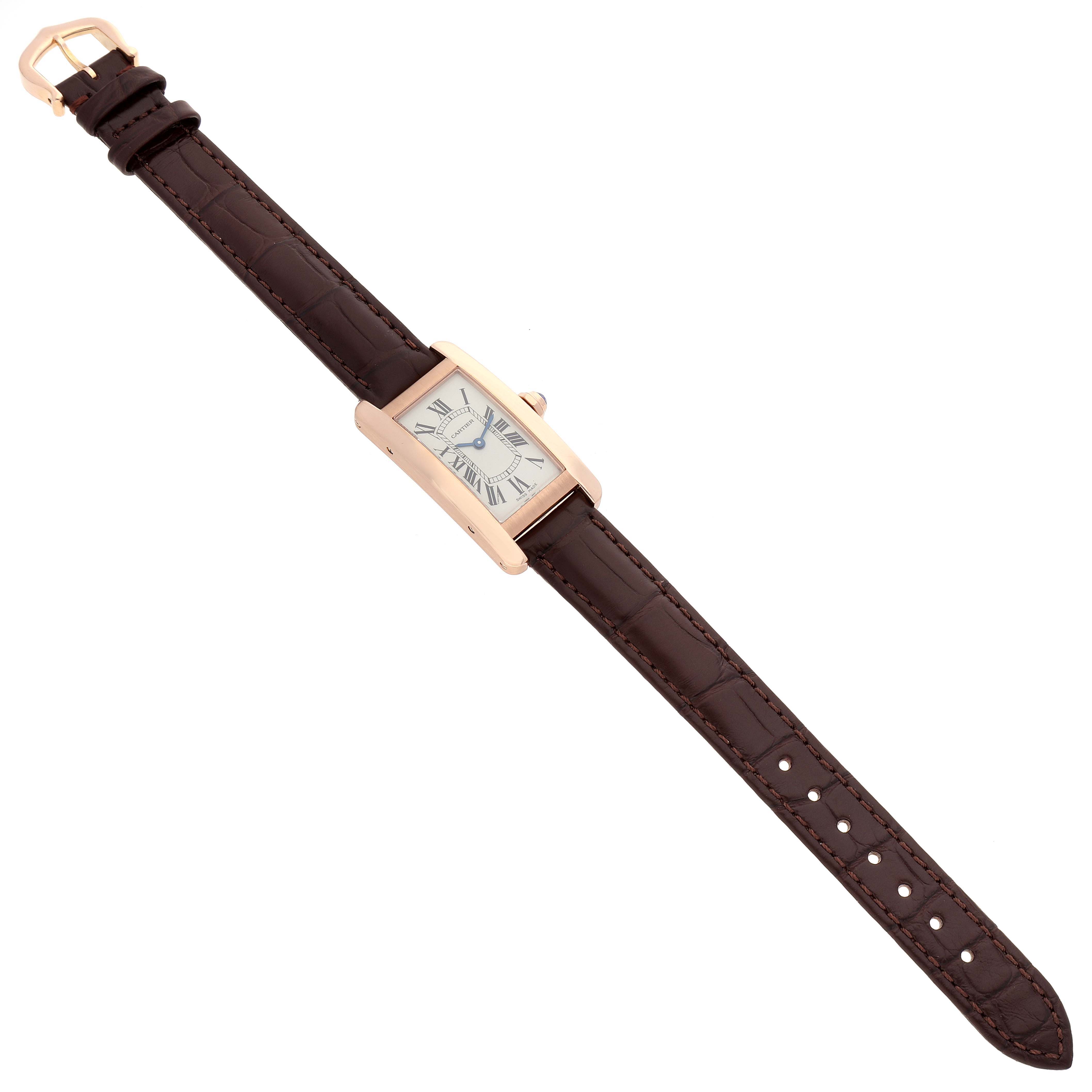 The Cartier Tank Americaine W2607456 Women
s Rose Gold Silver Dial W2607456 Women
s Rose Gold Silver Dial watch is shown from a top-down angle, displaying the entire watch, including the brown leather strap and rectangular face.