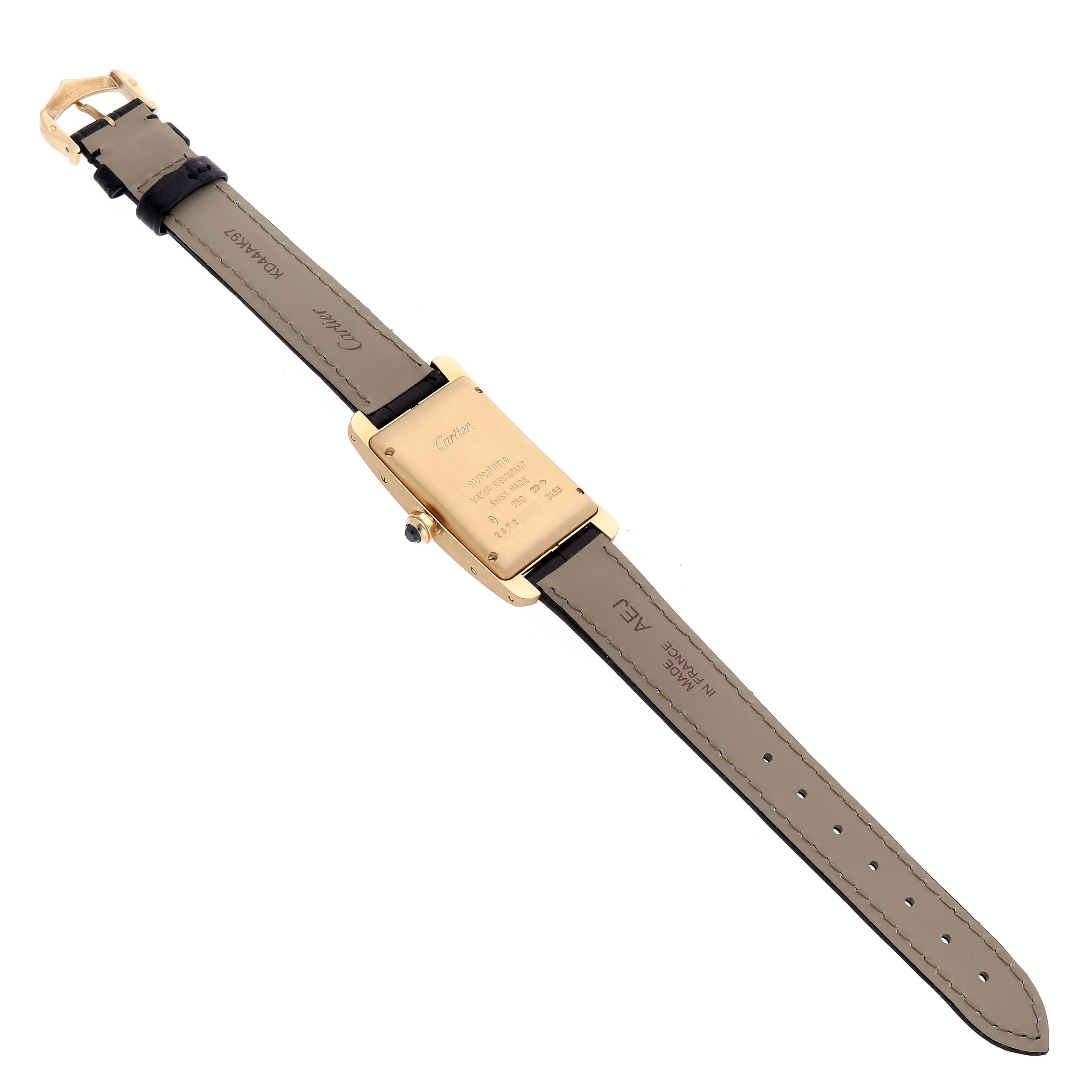 The Cartier Tank Americaine W2603556 Men's Yellow Gold Silver Dial watch is shown from the back, displaying its case, strap, and buckle.