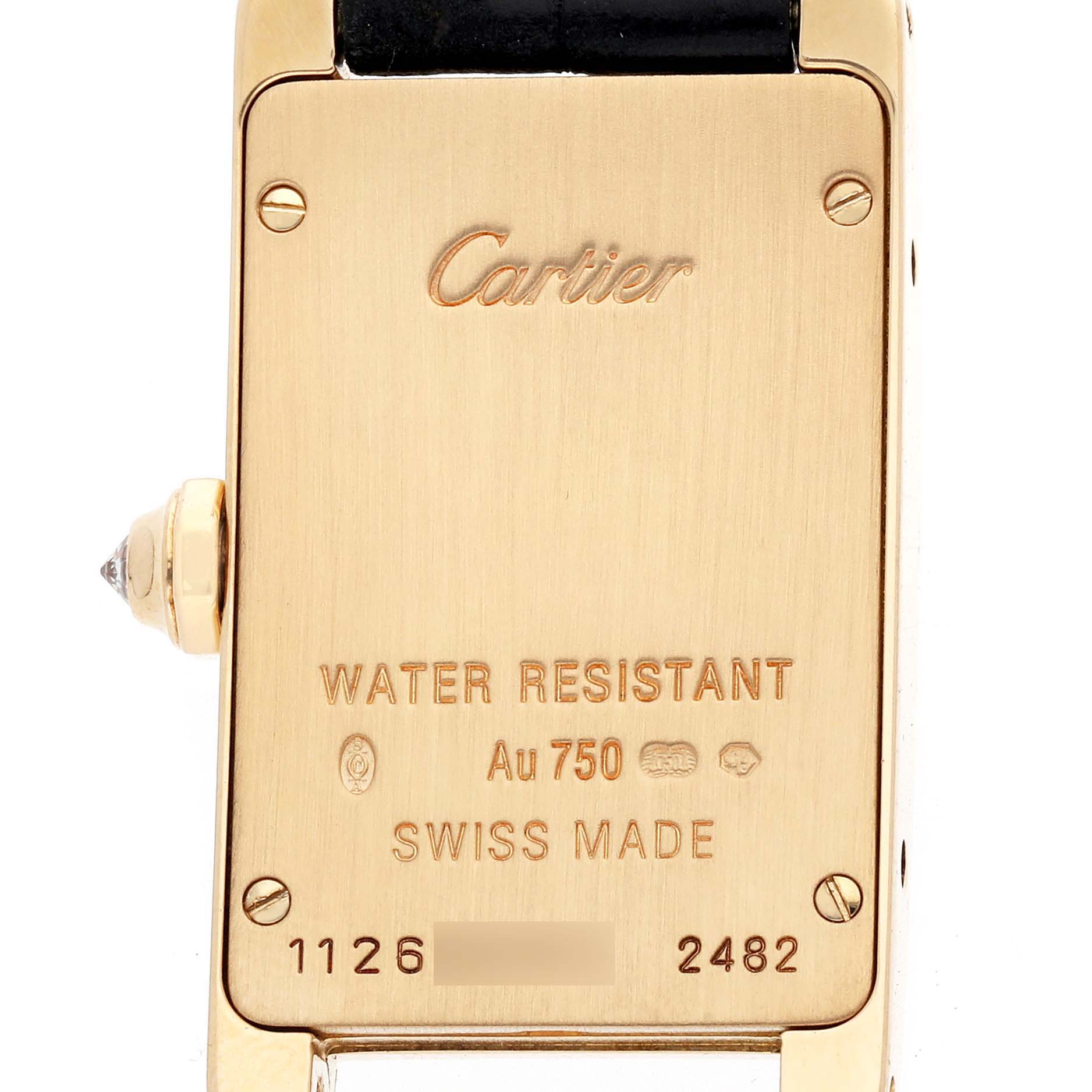 The image shows the back of the Cartier Tank Americaine WB707231 Women's Yellow Gold Silver Dial watch, highlighting engravings, screws, and part of the strap.