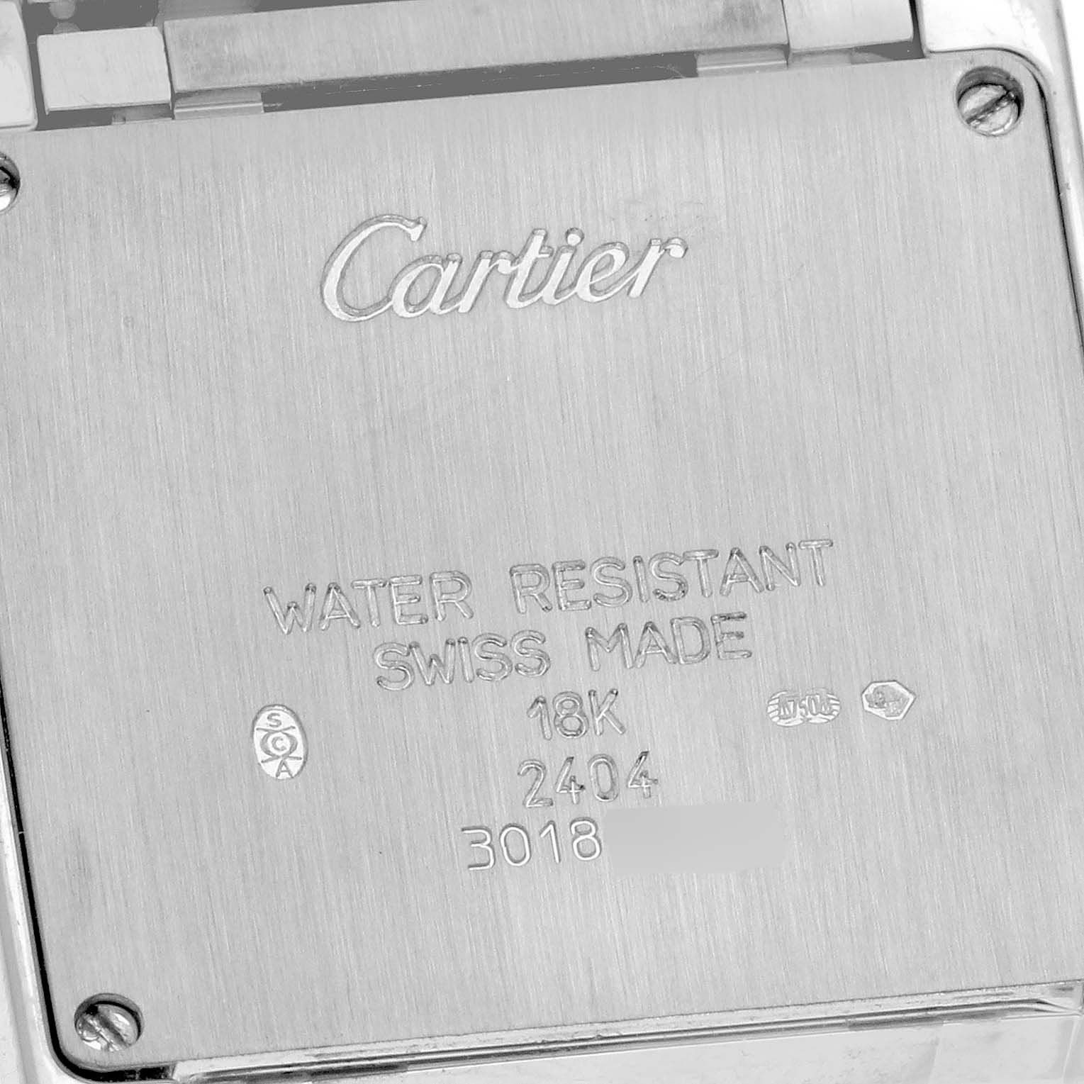 The image shows the back case of a Cartier Tank Française watch with engraved details.