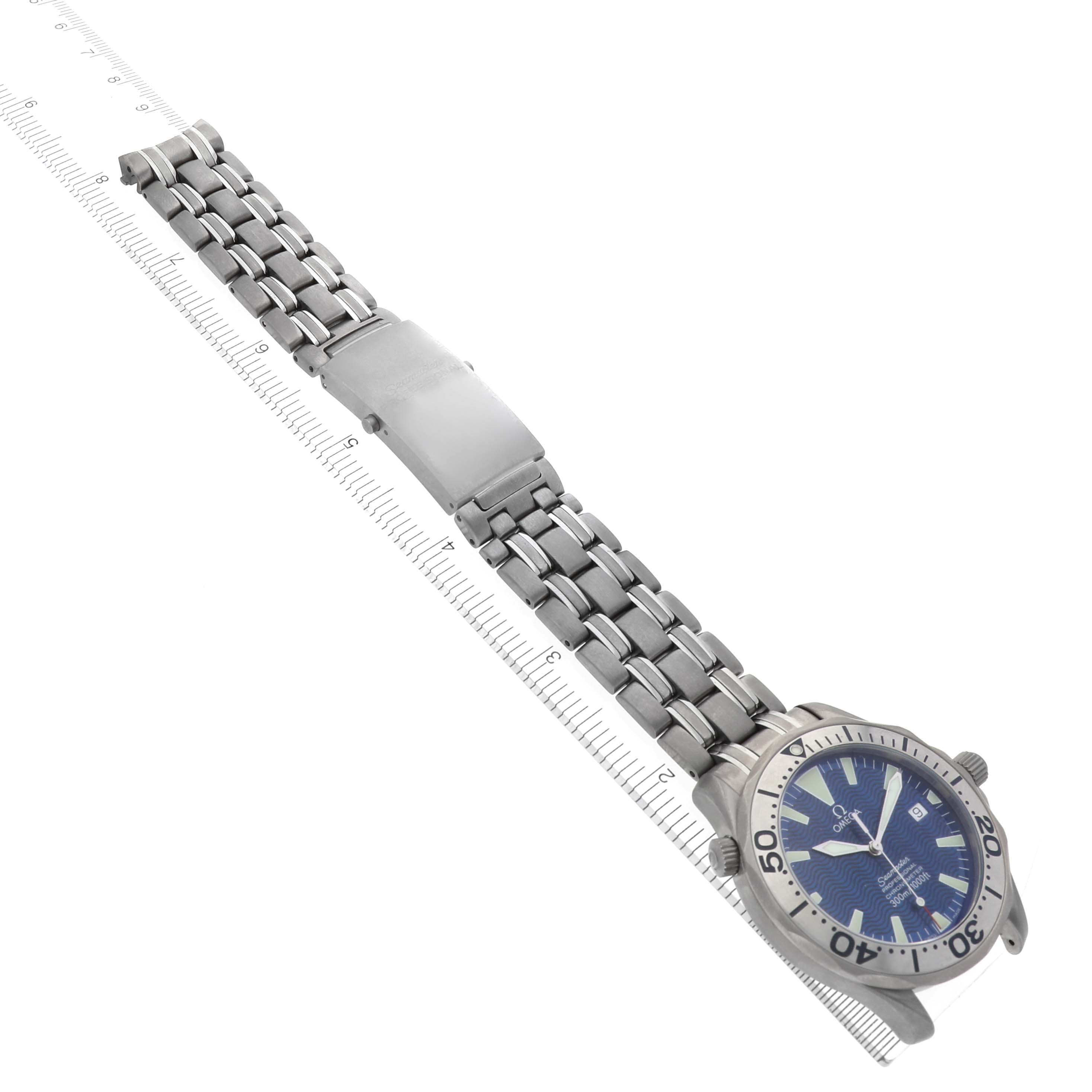 The image shows an Omega Seamaster 2231.80.00 Men's Titanium Blue Dial 2231.80.00 Men's Titanium Blue Dial watch at an angled side view, highlighting the face, bezel, and bracelet with a ruler for scale.