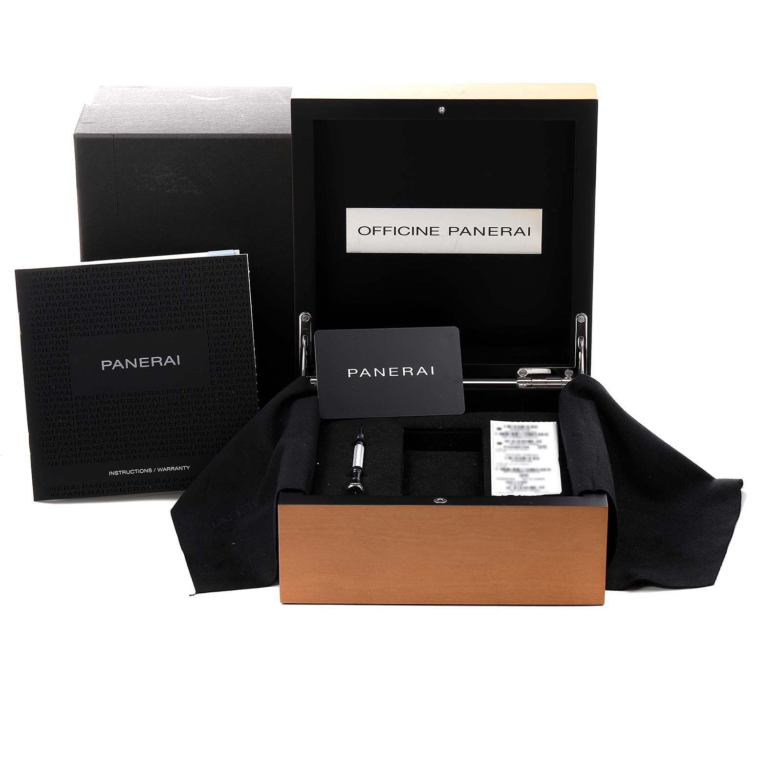 The image shows the packaging and accessories of a Panerai Luminor PAM00796 Men
s Stainless Steel Black Dial PAM00796 Men
s Stainless Steel Black Dial watch, including the box, manuals, and tools, from a frontal angle.