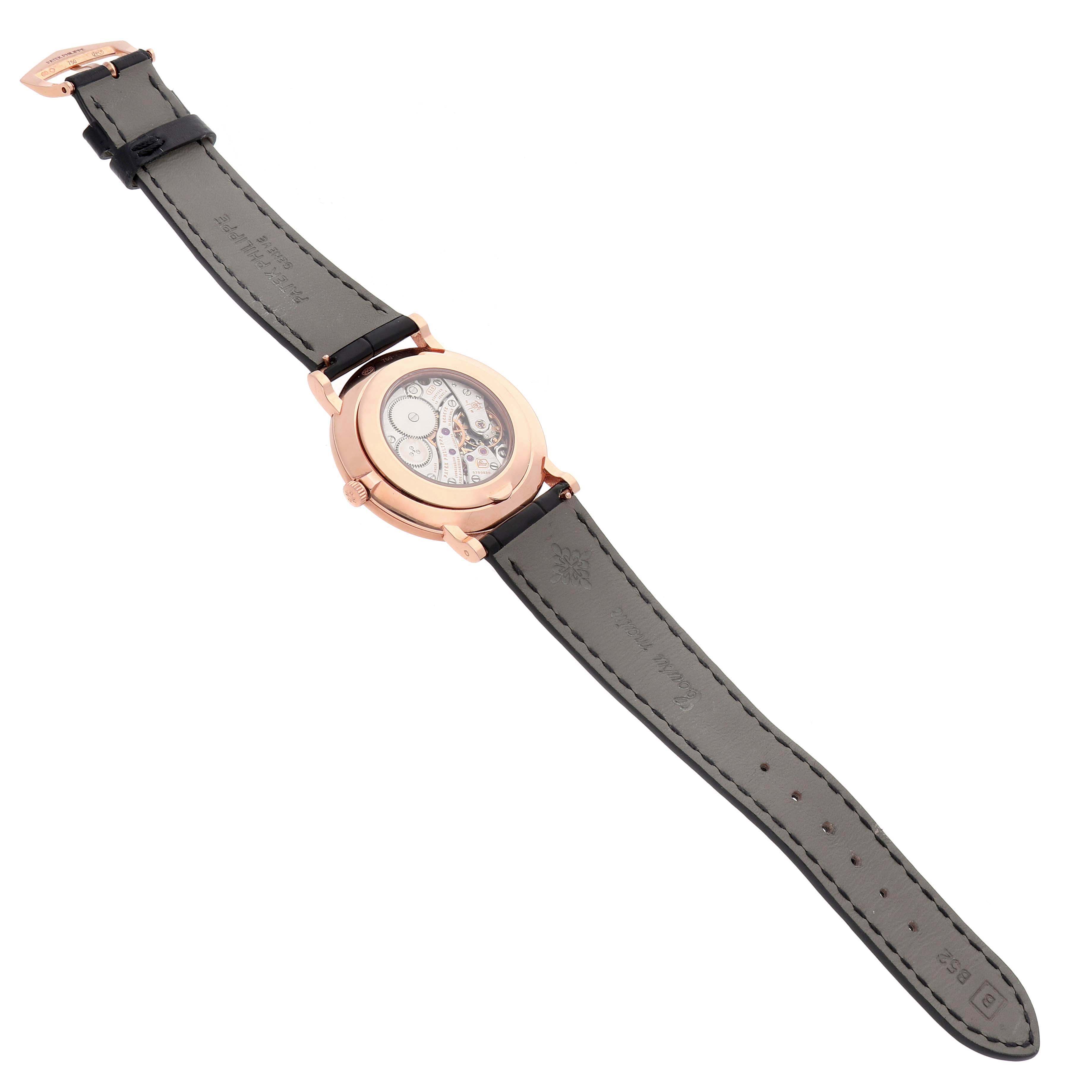 The image shows a Patek Philippe Calatrava 5116R Men's Rose Gold White Dial watch from the back, displaying the movement and leather strap.