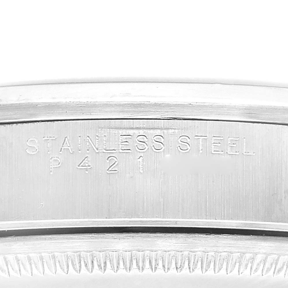 This close-up image shows the side of a Rolex Air-King 14000 Men's Stainless Steel Silver Dial 14000 Men's Stainless Steel Silver Dial watch with "STAINLESS STEEL" and serial number engraved.