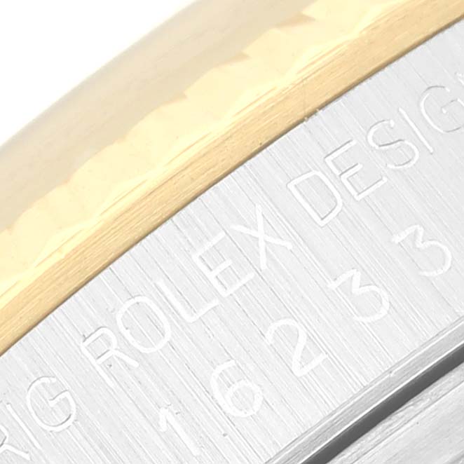 This is a close-up of the Rolex Datejust 16233 Men's Steel and Gold (two tone) Champagne Dial 16233 Men's Steel and Gold (two tone) Champagne Dial watch, showing part of the bezel and engraved text.