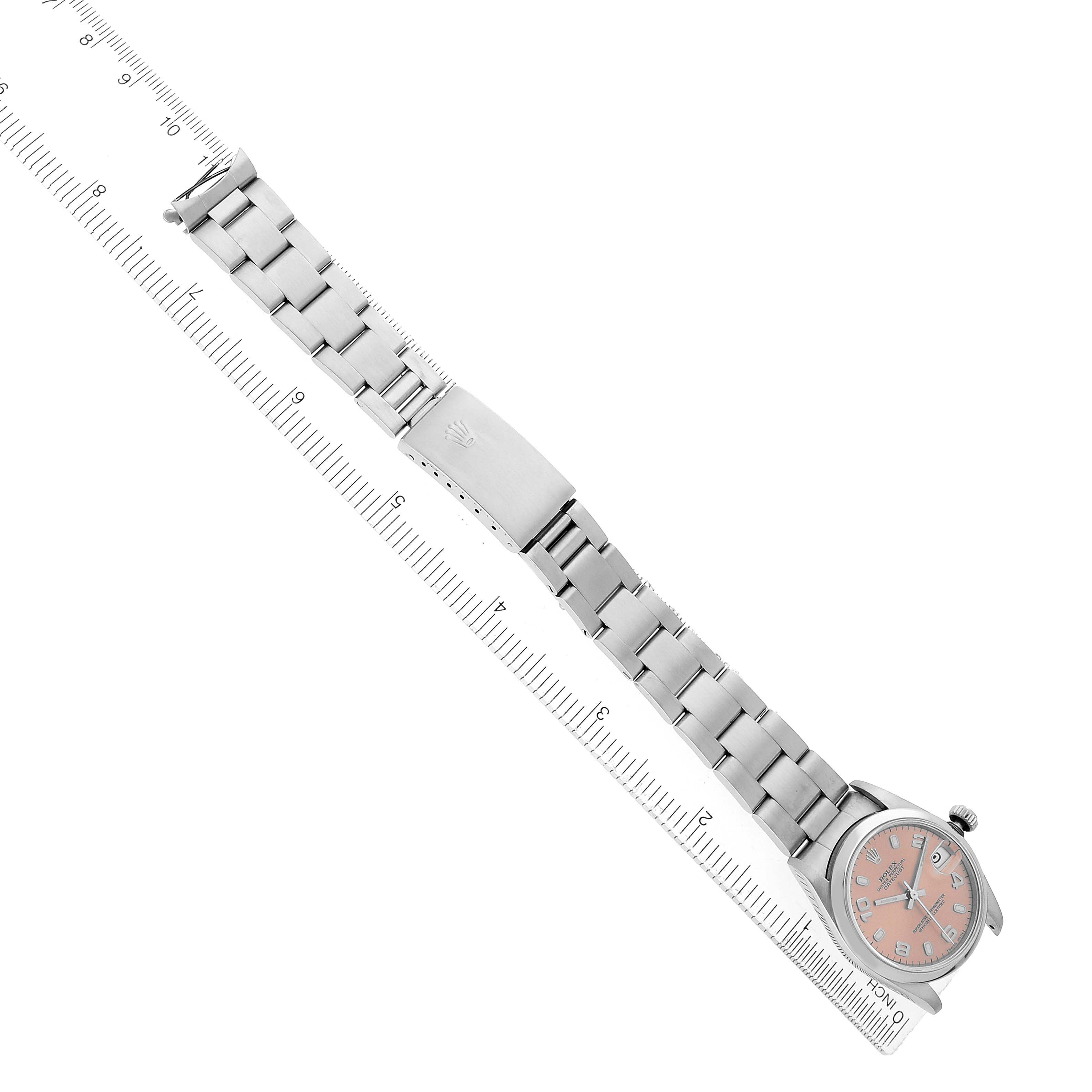 The Rolex Datejust 68240 Women's Stainless Steel Pink Dial watch is shown from above, highlighting the full bracelet and face, alongside a ruler.