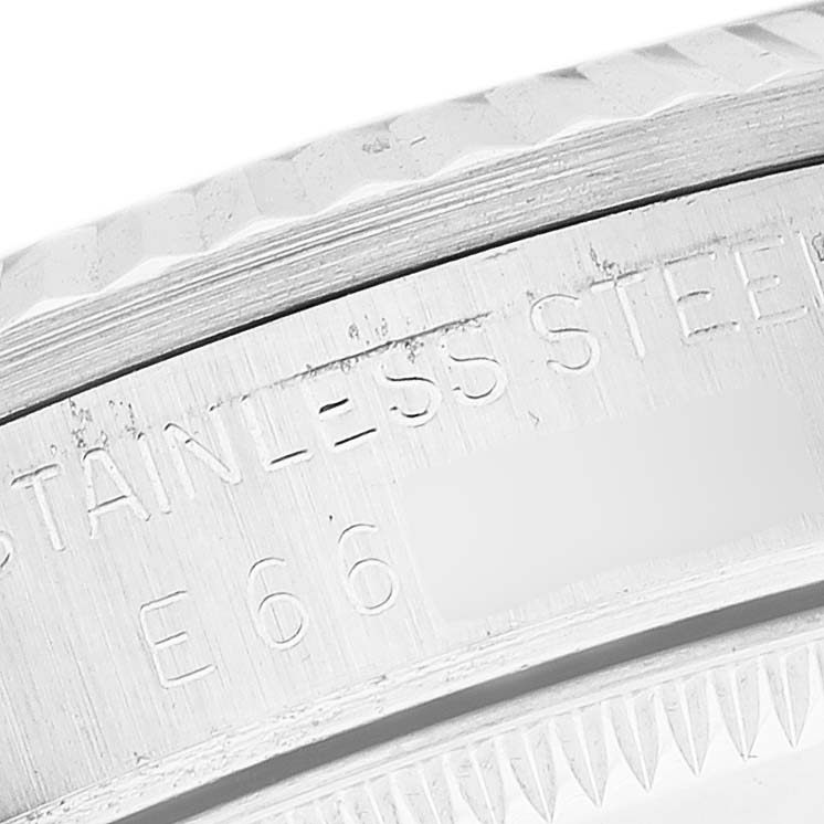 The image shows a close-up of the case back edge of the Rolex Mid-Size 68274 Women
s Stainless Steel Silver Dial 68274 Women
s Stainless Steel Silver Dial watch, highlighting the stainless steel material inscription.