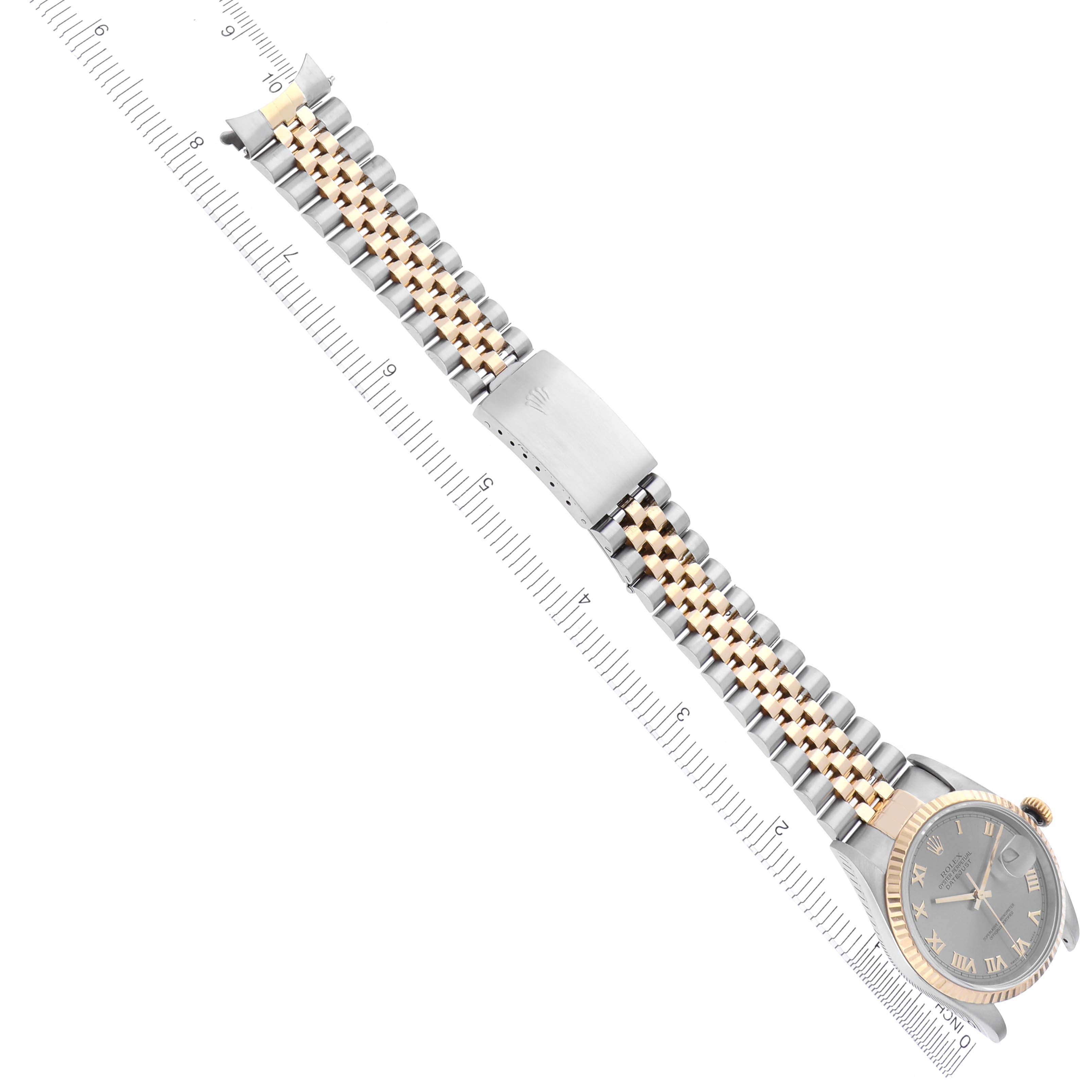 The image shows a Rolex Datejust 16233 Men's Steel and Gold (two tone) Grey Dial 16233 Men's Steel and Gold (two tone) Grey Dial watch with a two-tone bracelet and clasp, oriented diagonally over a ruler.