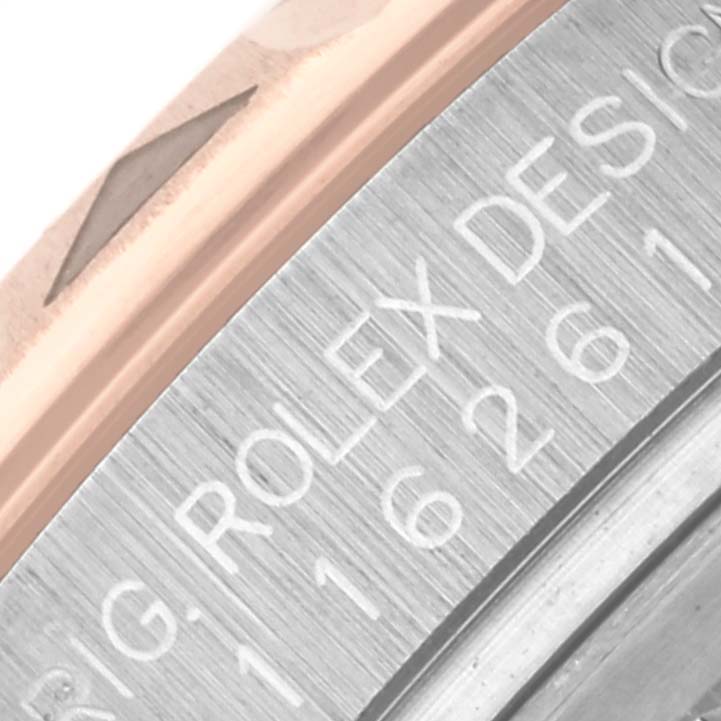 The image shows the edge of the Rolex Turn-o-Graph 116261 Men's Steel and Gold (two tone) White Dial 116261 Men's Steel and Gold (two tone) White Dial watch, focusing on the bezel and engraved case back.