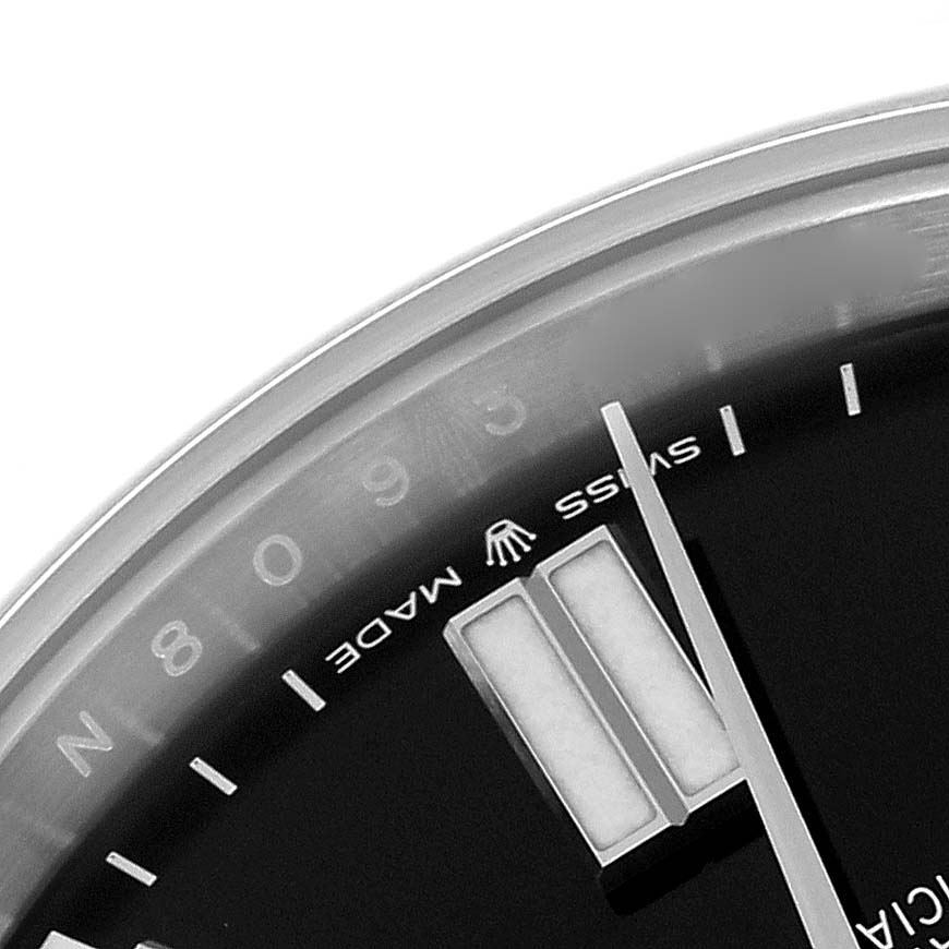 The image shows a close-up of the Rolex Oyster Perpetual 124300 Men
s Stainless Steel Black Dial 124300 Men
s Stainless Steel Black Dial
s dial, focusing on the hour markers and text.