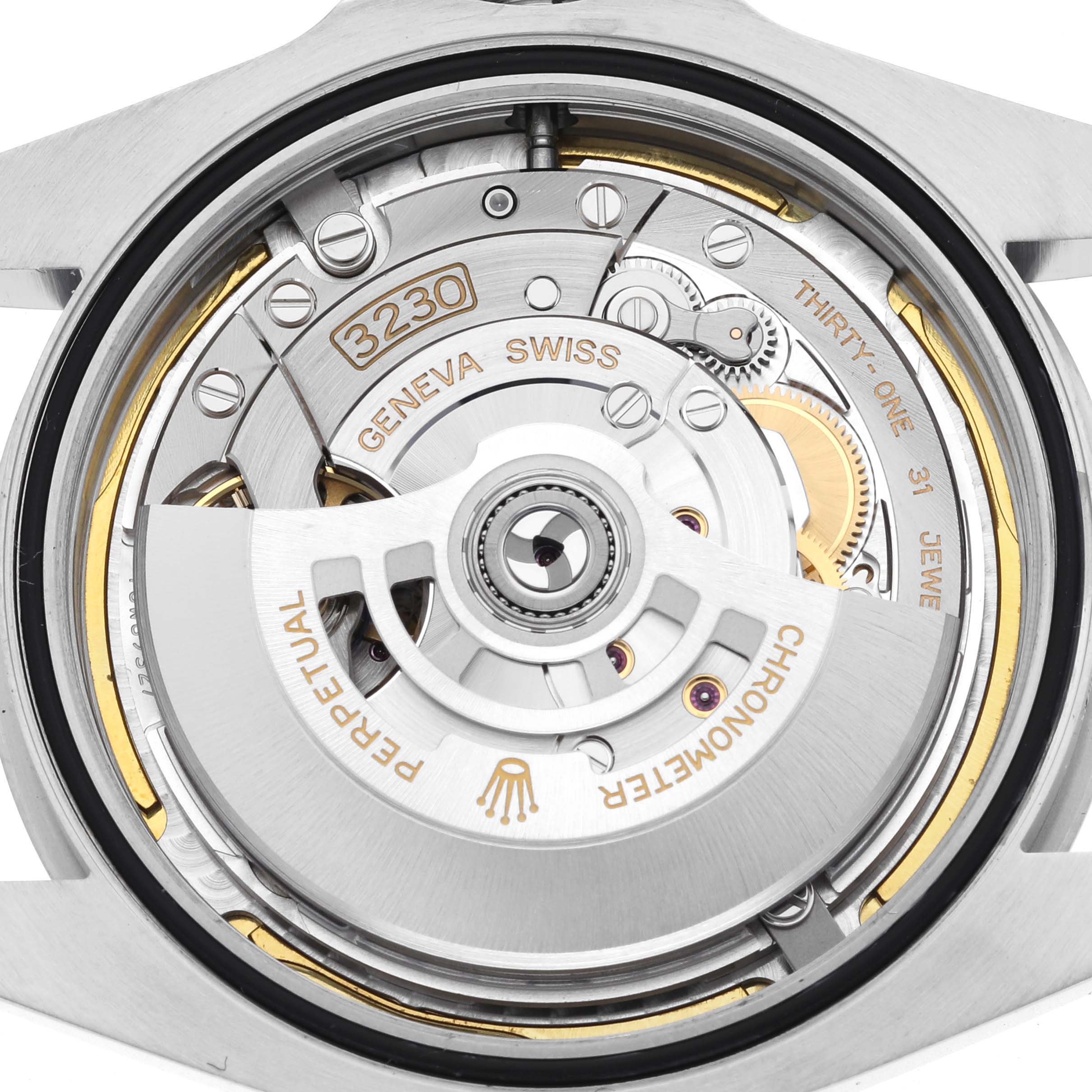 The image shows the movement of a Rolex Air-King 126900 Men's Stainless Steel Black Dial 126900 Men's Stainless Steel Black Dial watch from a rear angle, highlighting the rotor and internal mechanisms.