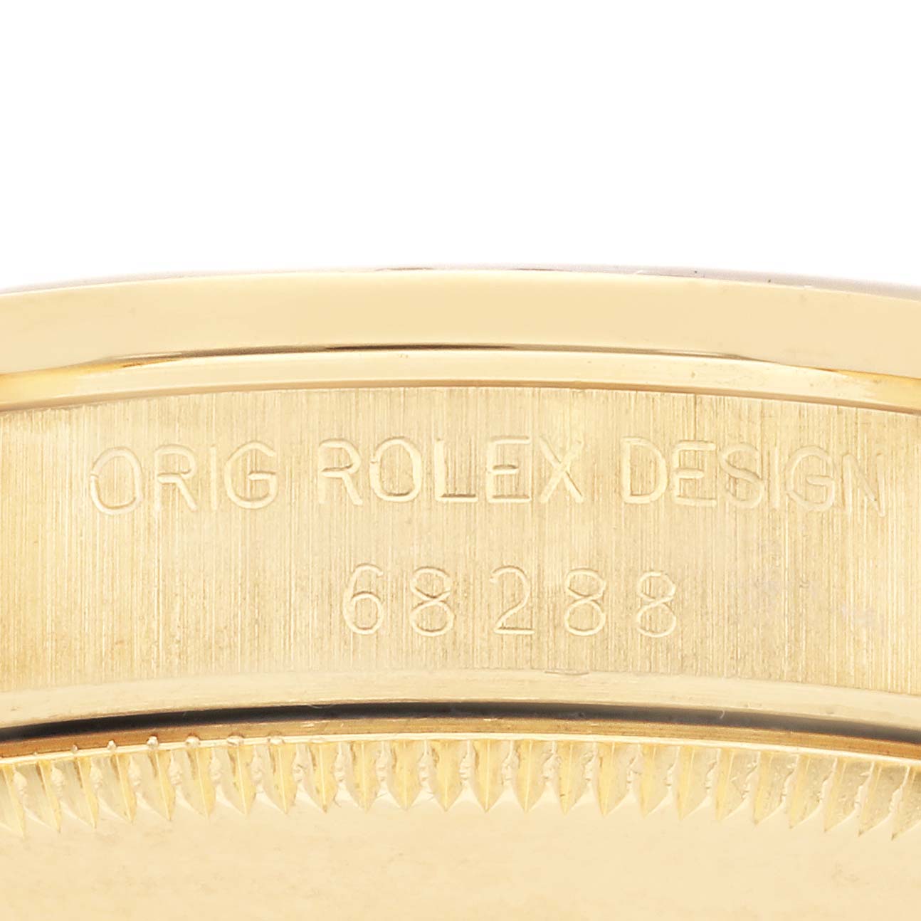 The image shows the side of a Rolex Mid-Size 68288 Women's Yellow Gold Champagne Dial 68288 Women's Yellow Gold Champagne Dial watch, highlighting the engraved text on the case.