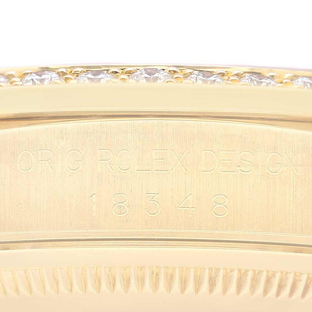 The image shows a close-up view of the engraved case side of a Rolex President 18348 Men
s Yellow Gold Champagne Dial 18348 Men
s Yellow Gold Champagne Dial model, featuring diamonds along the edge.