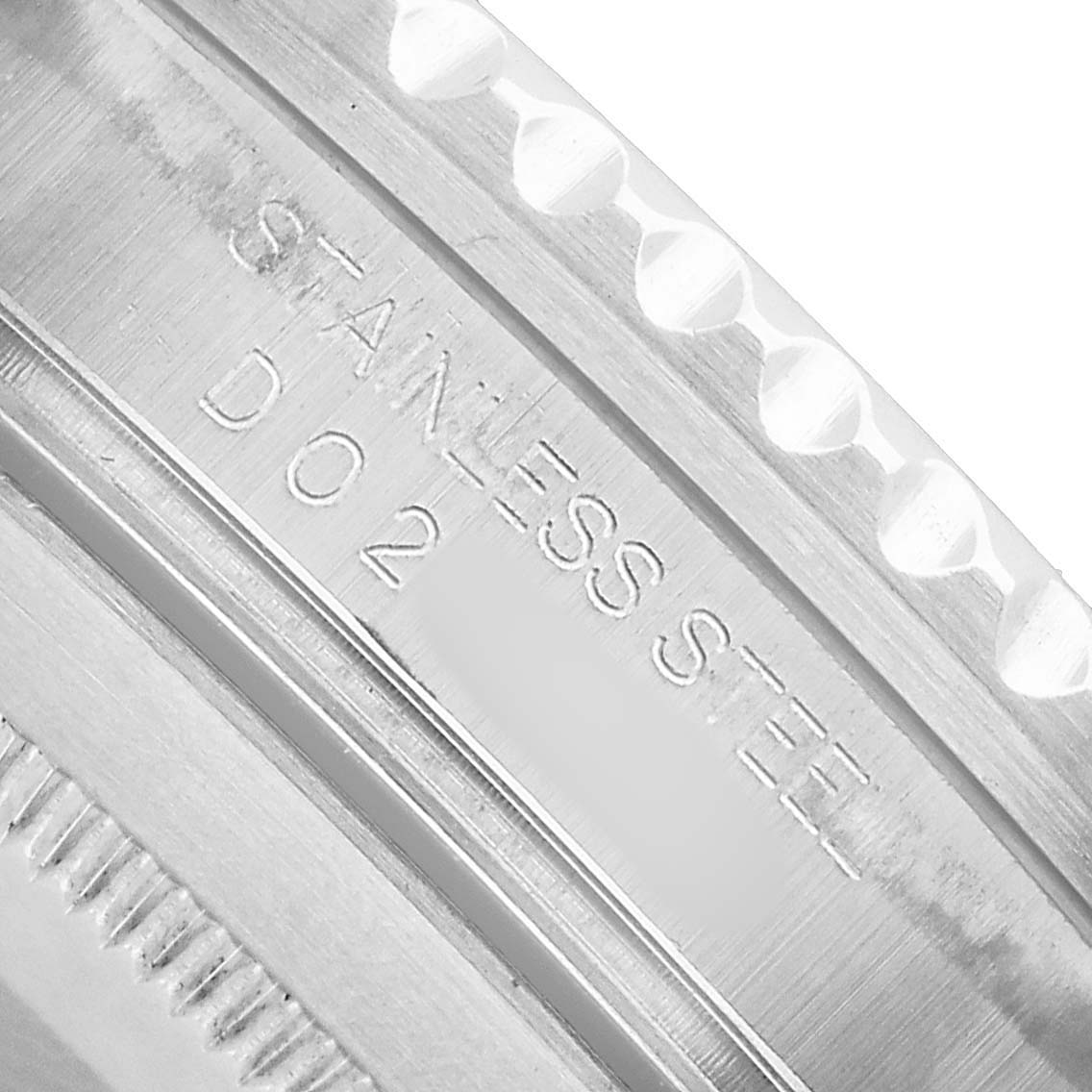 The image shows a close-up of the Rolex Submariner 16610 Men's Stainless Steel Black Dial watch bezel and case edge, highlighting the stainless steel material engraving.