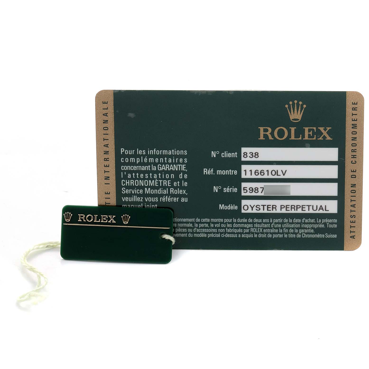 The image shows a Rolex Submariner 116610LV Men's Stainless Steel Green Dial model warranty card and tag at an angle where both are fully visible.
