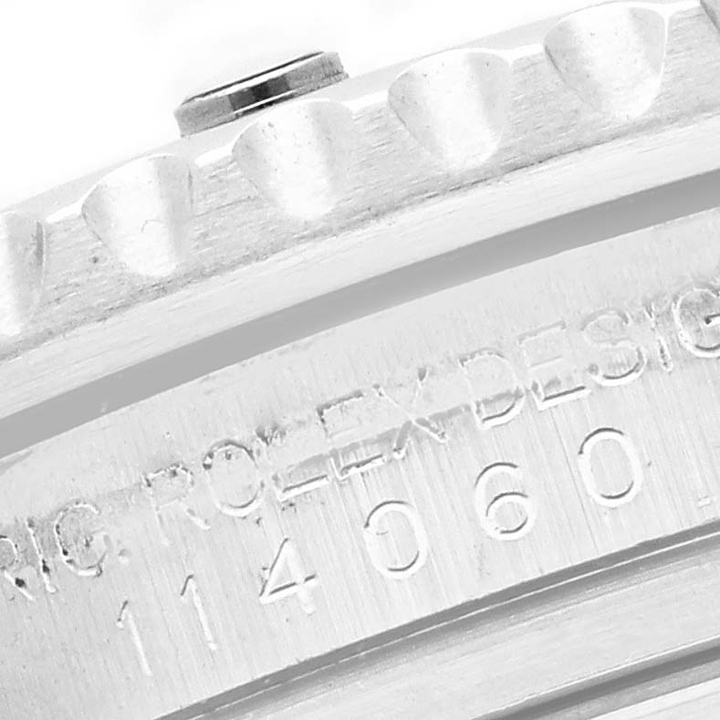 The image shows a close-up of the case back and edge of the Rolex Submariner 114060 Men's Stainless Steel Black Dial, highlighting the engravings and bezel.