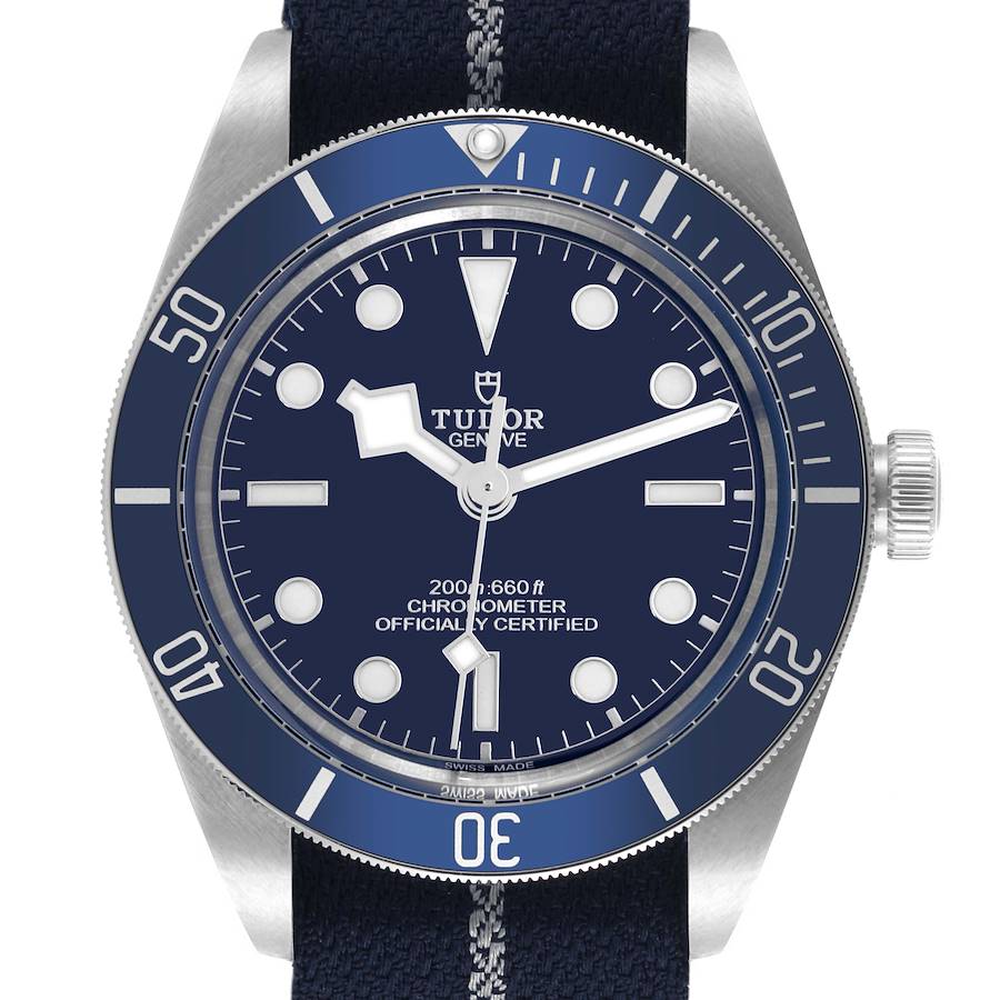 The Tudor Heritage Black Bay watch is shown from a front angle, displaying the dial, bezel, and case clearly.