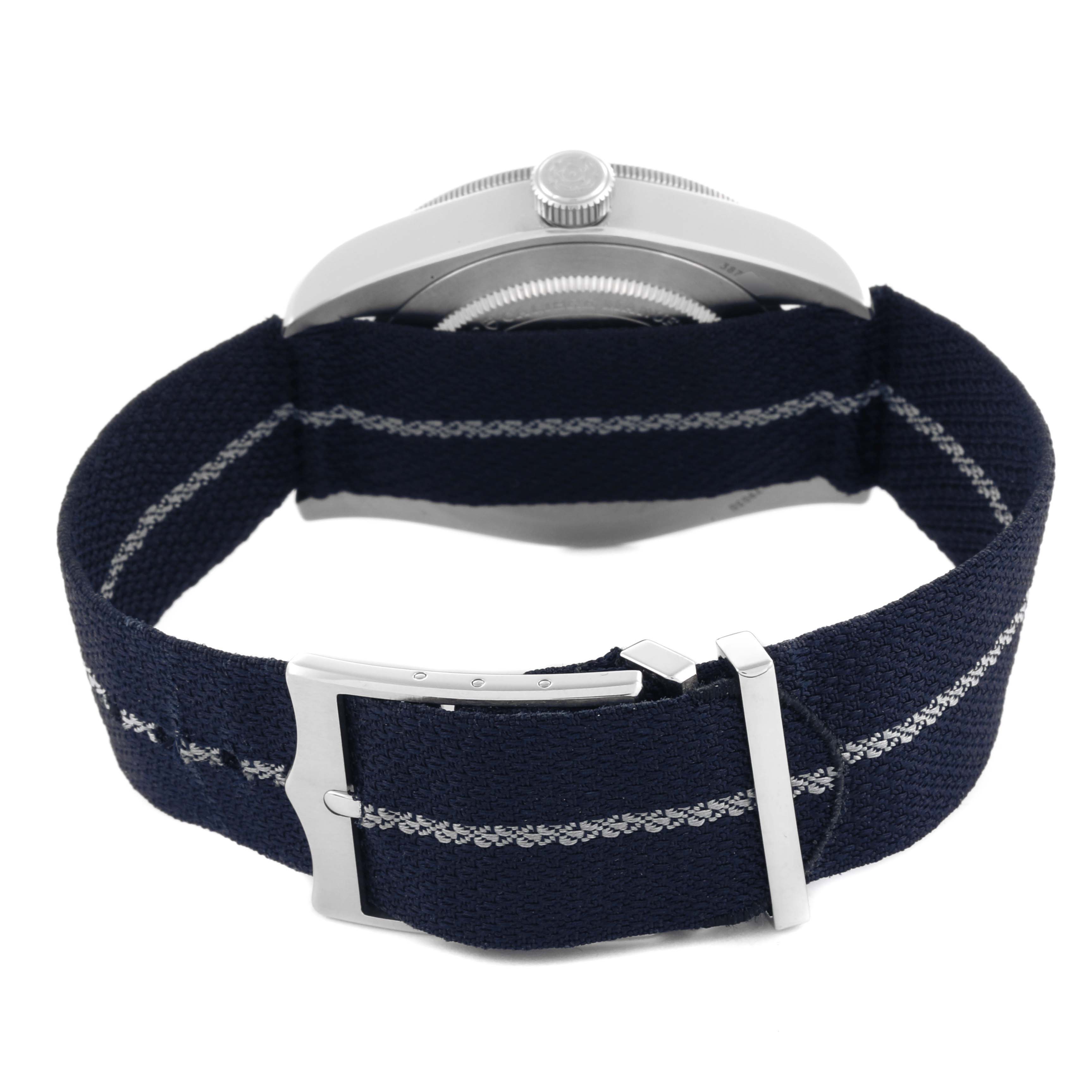 The Tudor Heritage Black Bay 79030 Men's Stainless Steel Blue Dial 79030 Men's Stainless Steel Blue Dial watch is shown from the side, highlighting the fabric strap and clasp.