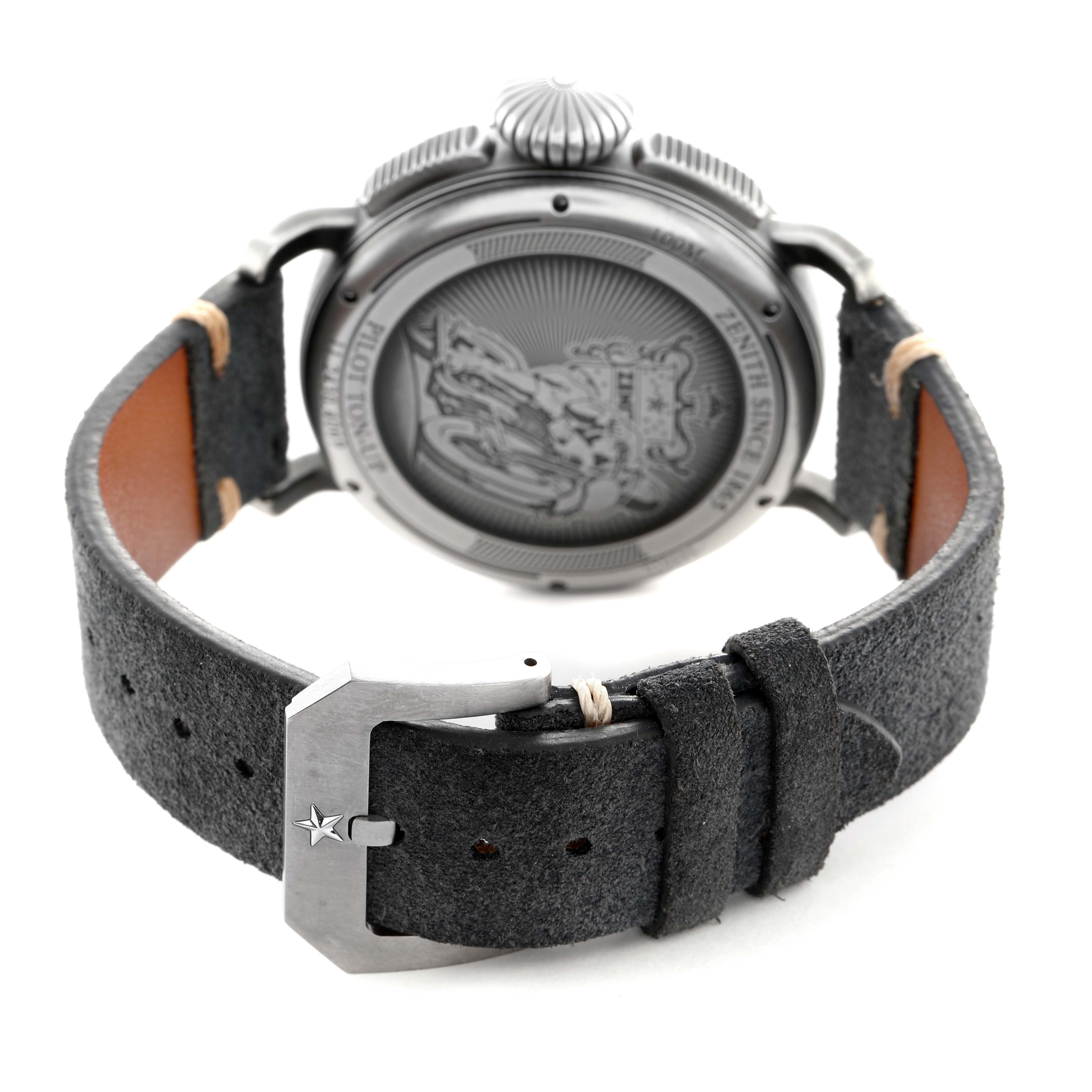 The Zenith Pilot 11.2430.4069 Men's Stainless Steel Grey Dial watch is shown from the back, highlighting the engraved case back, crown, and leather strap with a buckle.