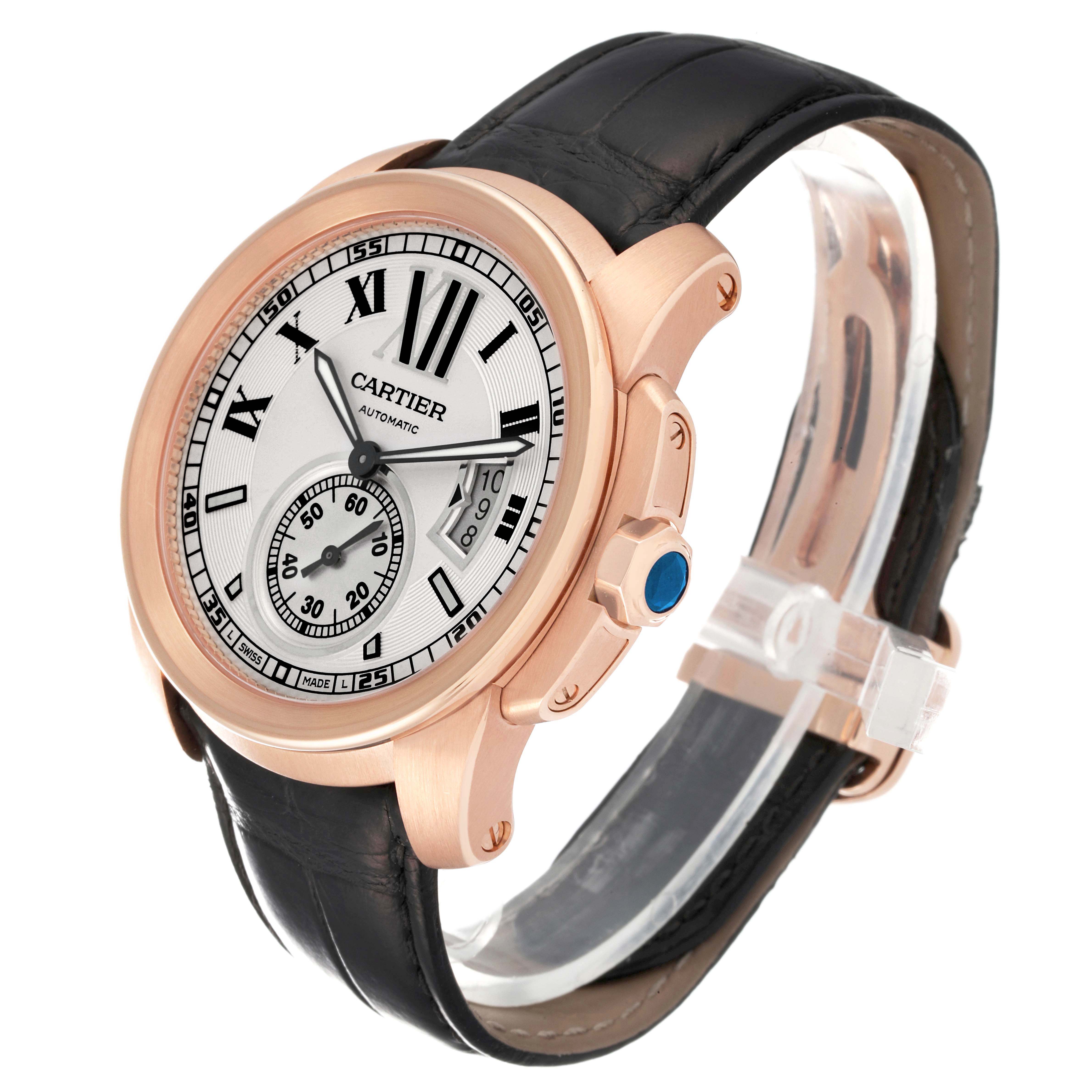 The Calibre de Cartier watch is shown in a three-quarter angle, highlighting the face, crown, and leather strap.
